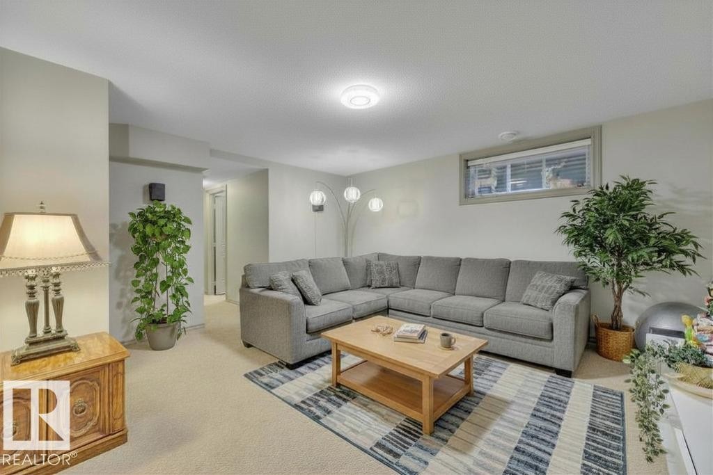 In basement - virtually staged with sectional - 1611 63 Street, Edmonton, AB - Indoor Photo Showing Living Room