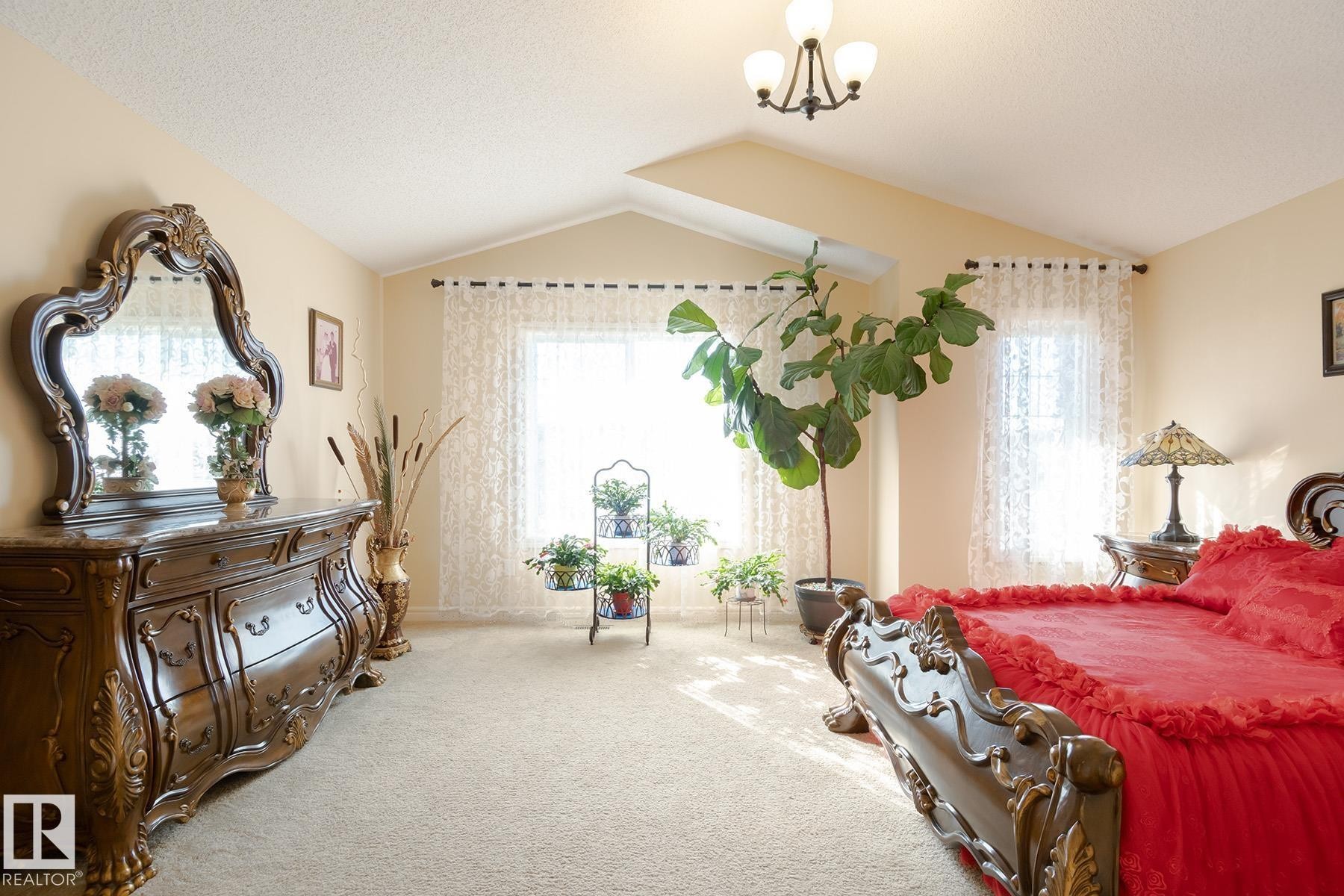 Spacious room featuring vaulted ceilings, light carpeting, and dual windows with sheer curtains - 7426 Getty Way, Edmonton, AB - Indoor Photo Showing Bedroom