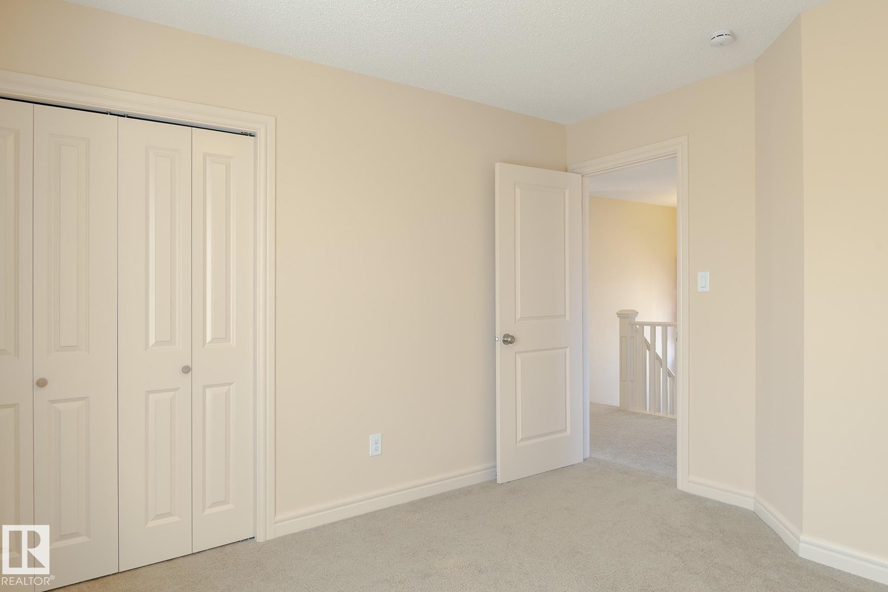 Soft neutral wall paint with coordinating carpet flooring - 7426 Getty Way, Edmonton, AB - Indoor Photo Showing Other Room