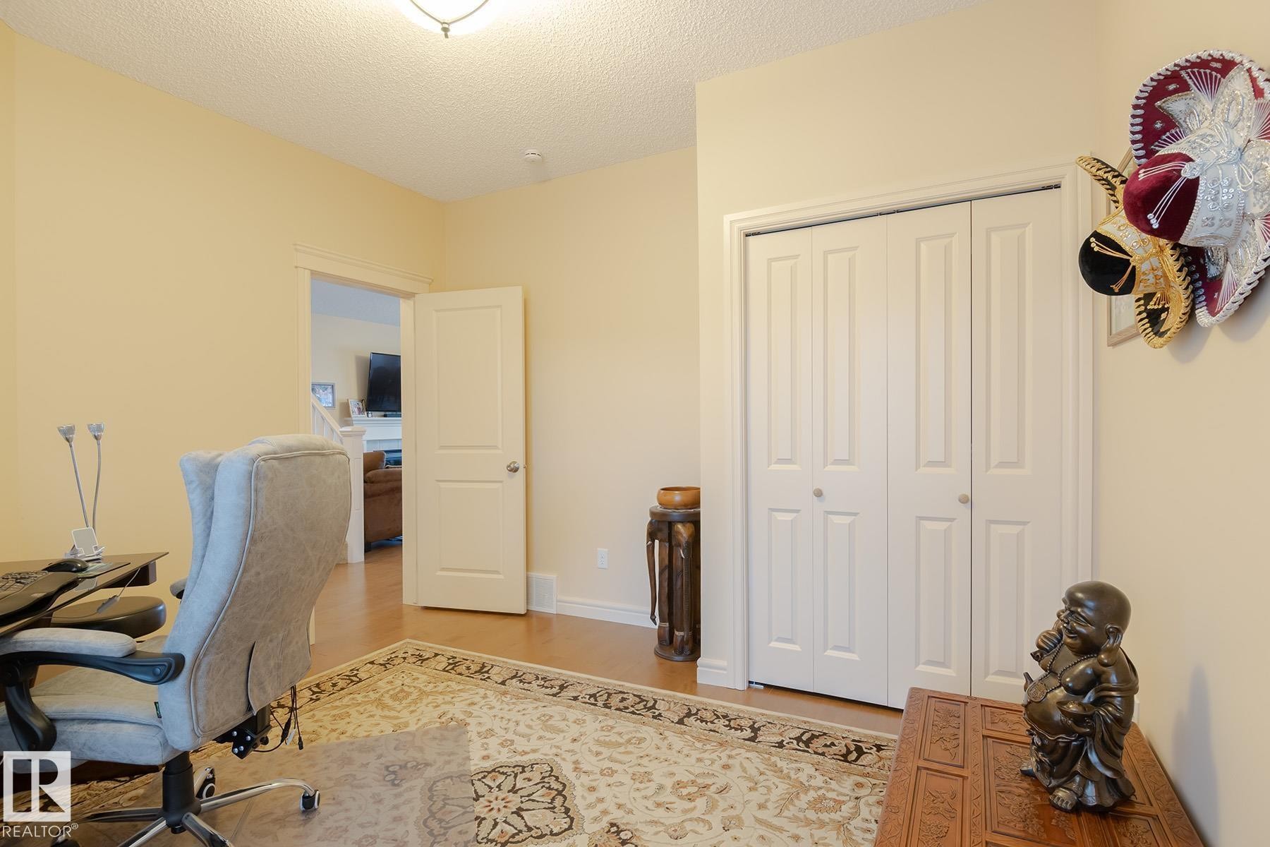 Room featuring wood-finish flooring, light-toned walls, and a ceiling-mounted light fixture - 7426 Getty Way, Edmonton, AB - Indoor