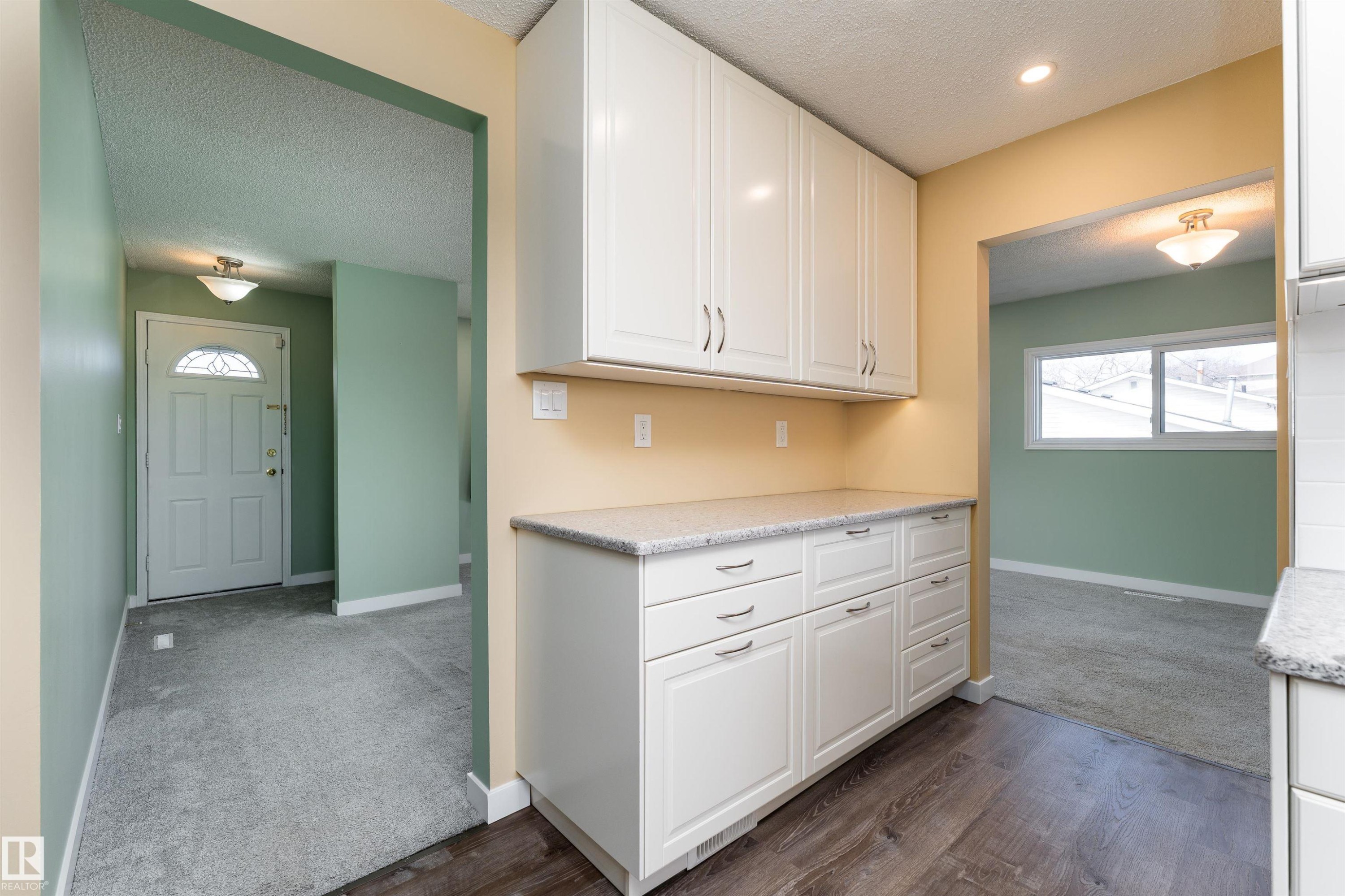 Kitchenette featuring white cabinetry, light-colored countertops, and wood-finish flooring - 13331 64 Street Nw, Edmonton, AB - Indoor Photo Showing Other Room