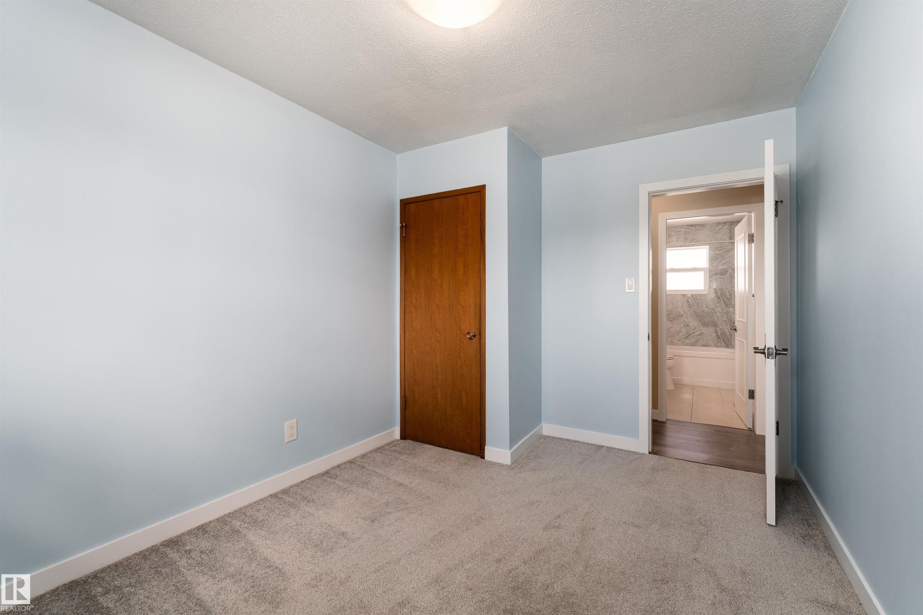 Spacious room featuring light blue walls, plush grey carpeting, and white baseboards - 13331 64 Street Nw, Edmonton, AB - Indoor Photo Showing Other Room