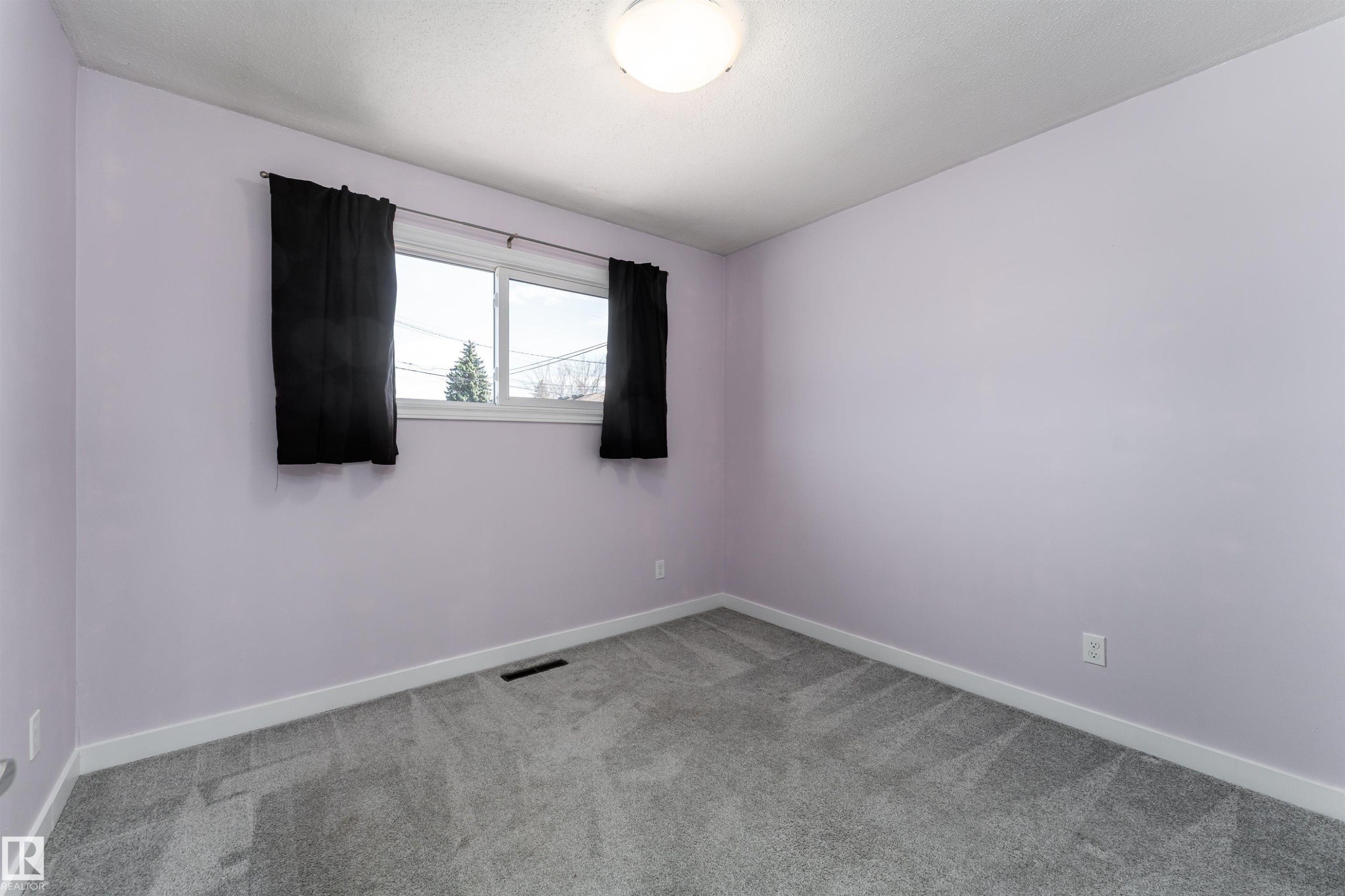 Carpeted interior room featuring light lavender walls, a double-paned window, and a flush mount ceiling light - 13331 64 Street Nw, Edmonton, AB - Indoor Photo Showing Other Room