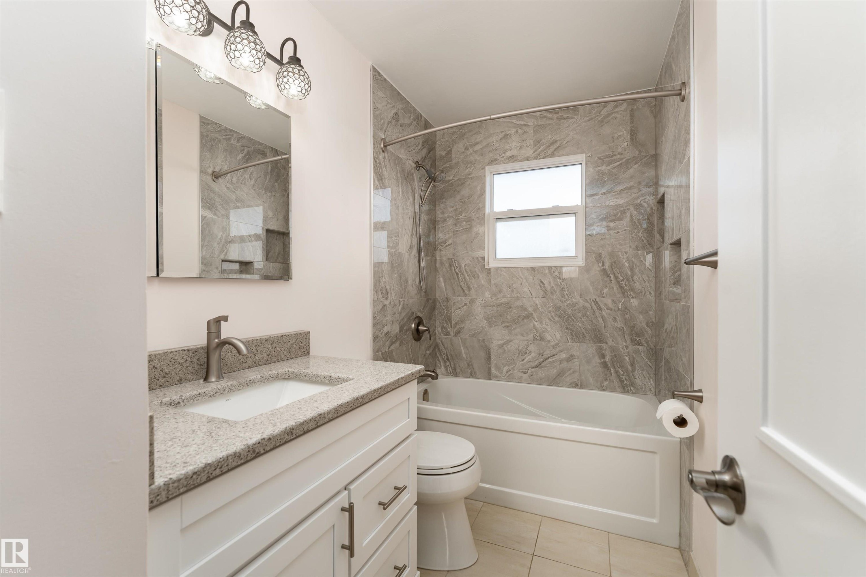 Bathroom featuring a white vanity with a light-toned countertop and an undermount sink - 13331 64 Street Nw, Edmonton, AB - Indoor Photo Showing Bathroom