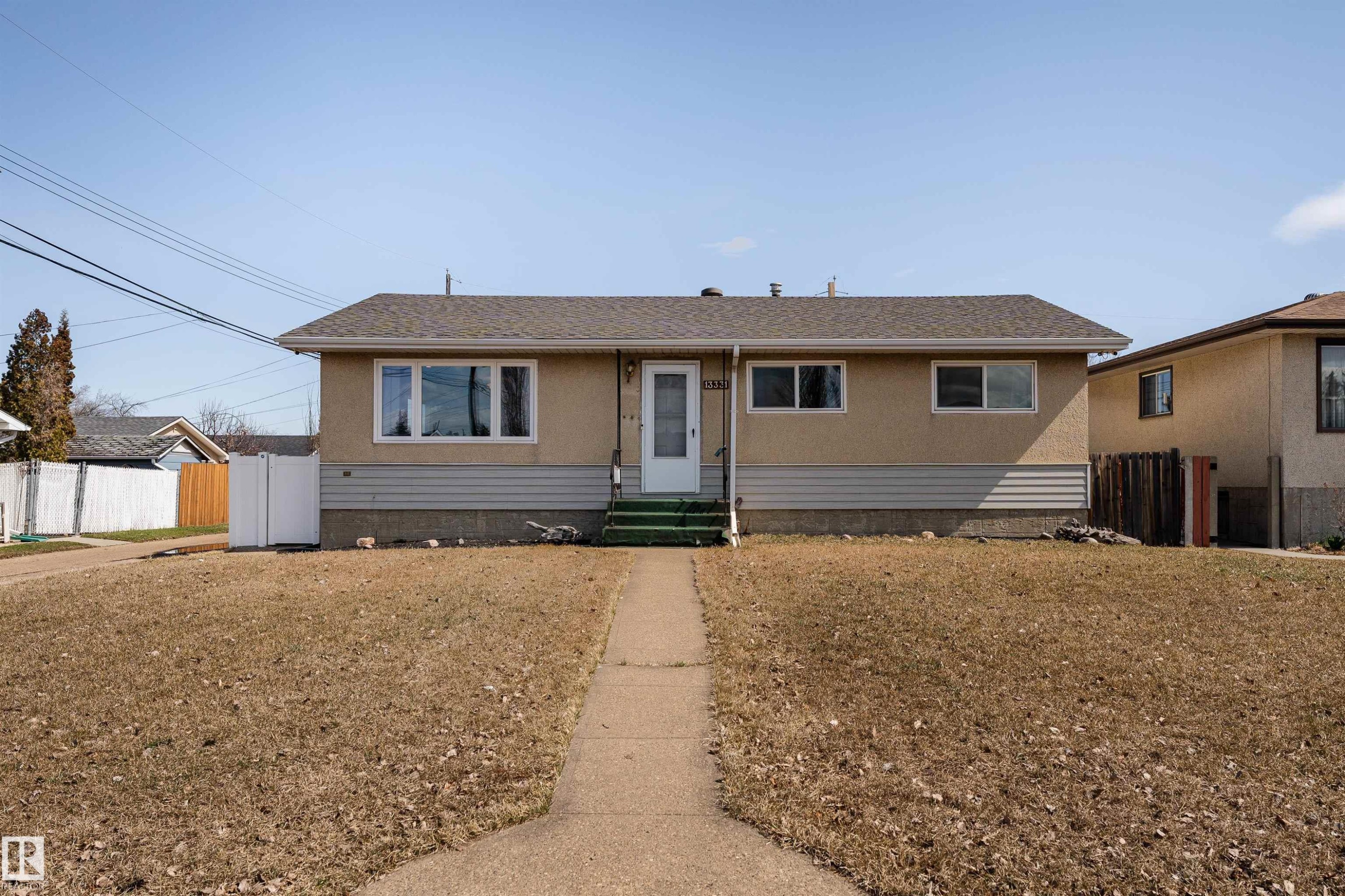 Stucco exterior with a pitched shingle roof - 13331 64 Street Nw, Edmonton, AB - Outdoor