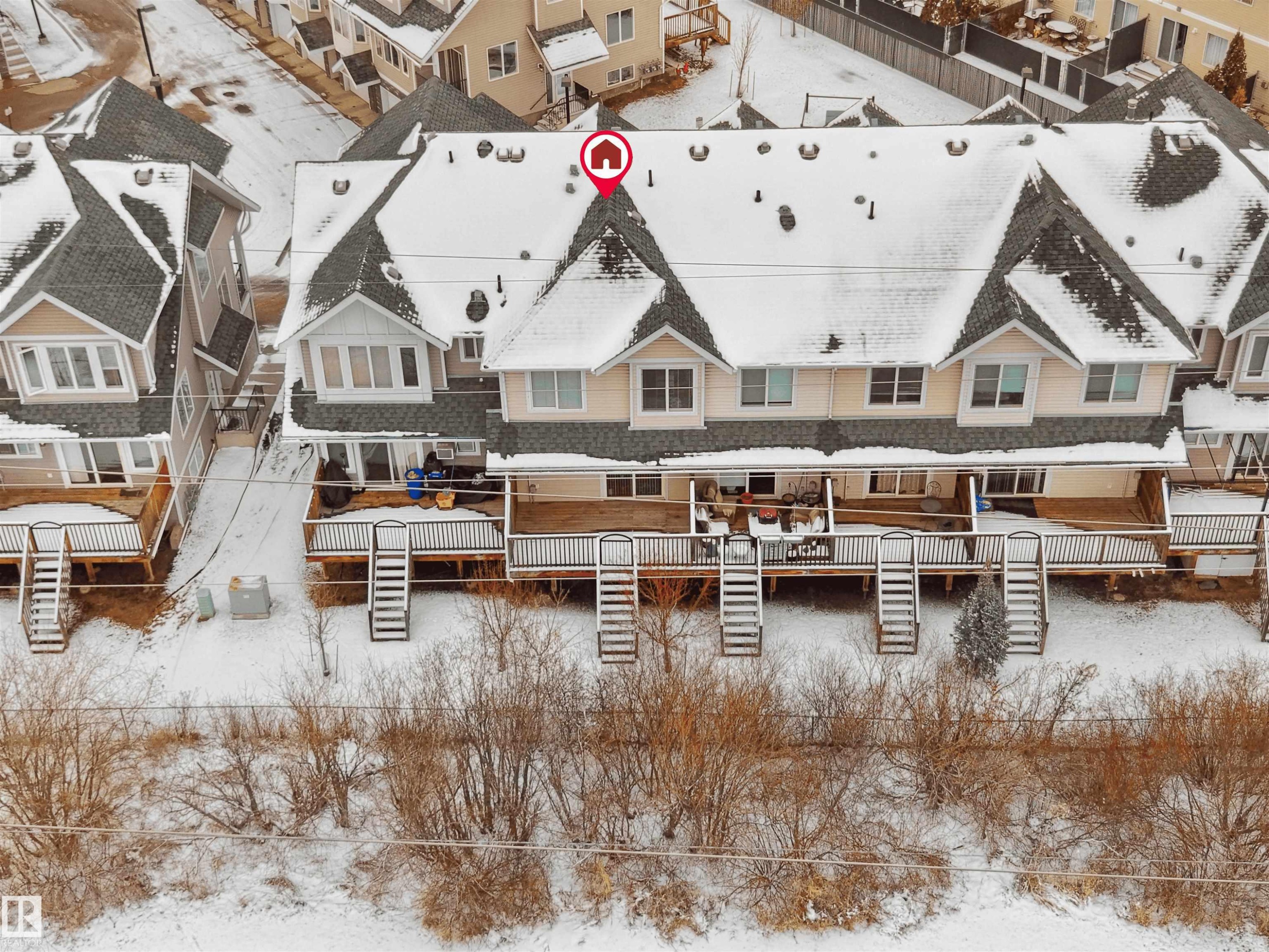 Townhome property featuring individual rear decks with stairs descending to a snow-covered private yard - #11 13215 153 Avenue, Edmonton, AB - Outdoor