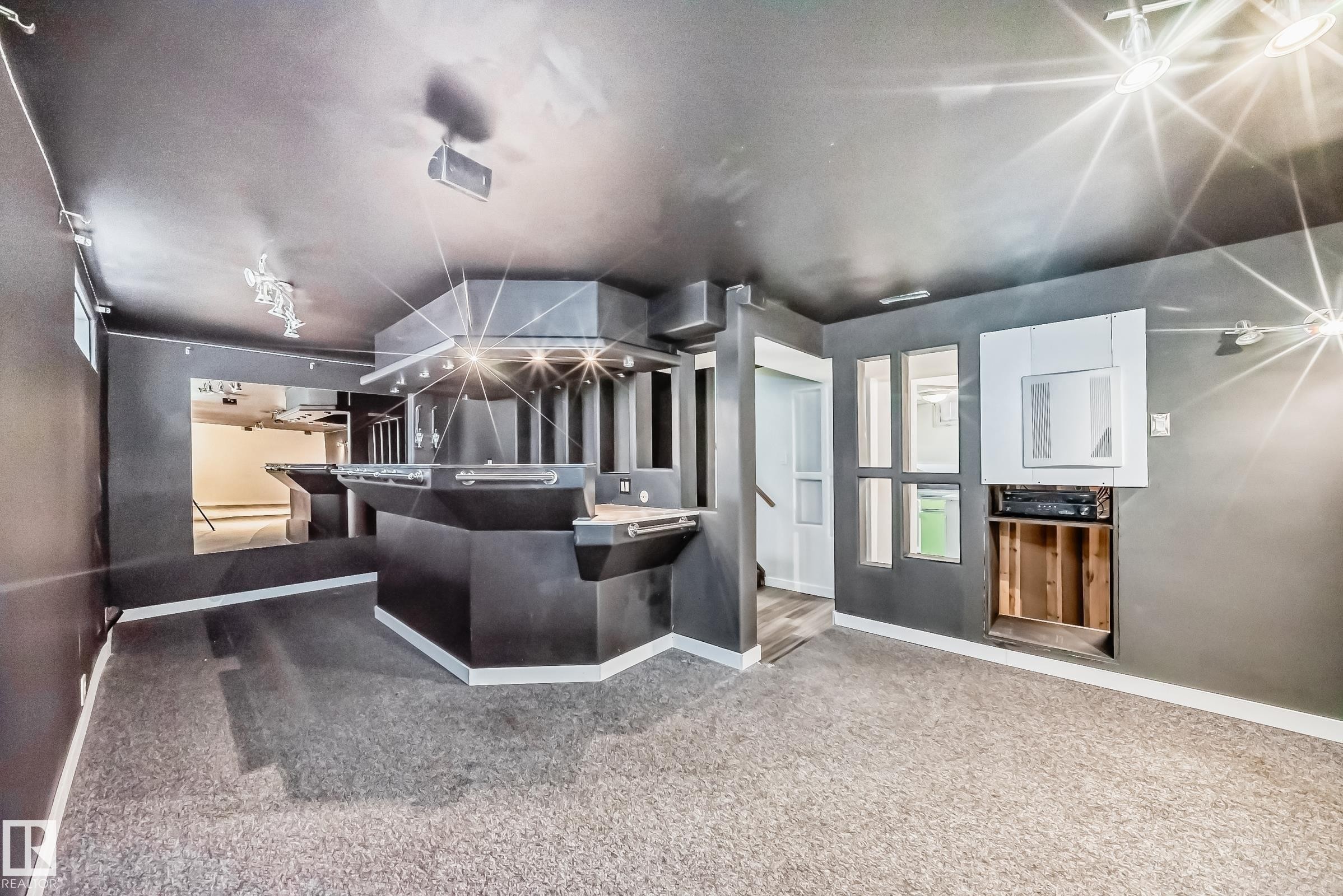 Recreational space featuring a built-in bar with multiple service stations, integrated lighting, and a textured countertop - 5204 112 Avenue Nw, Edmonton, AB - Indoor