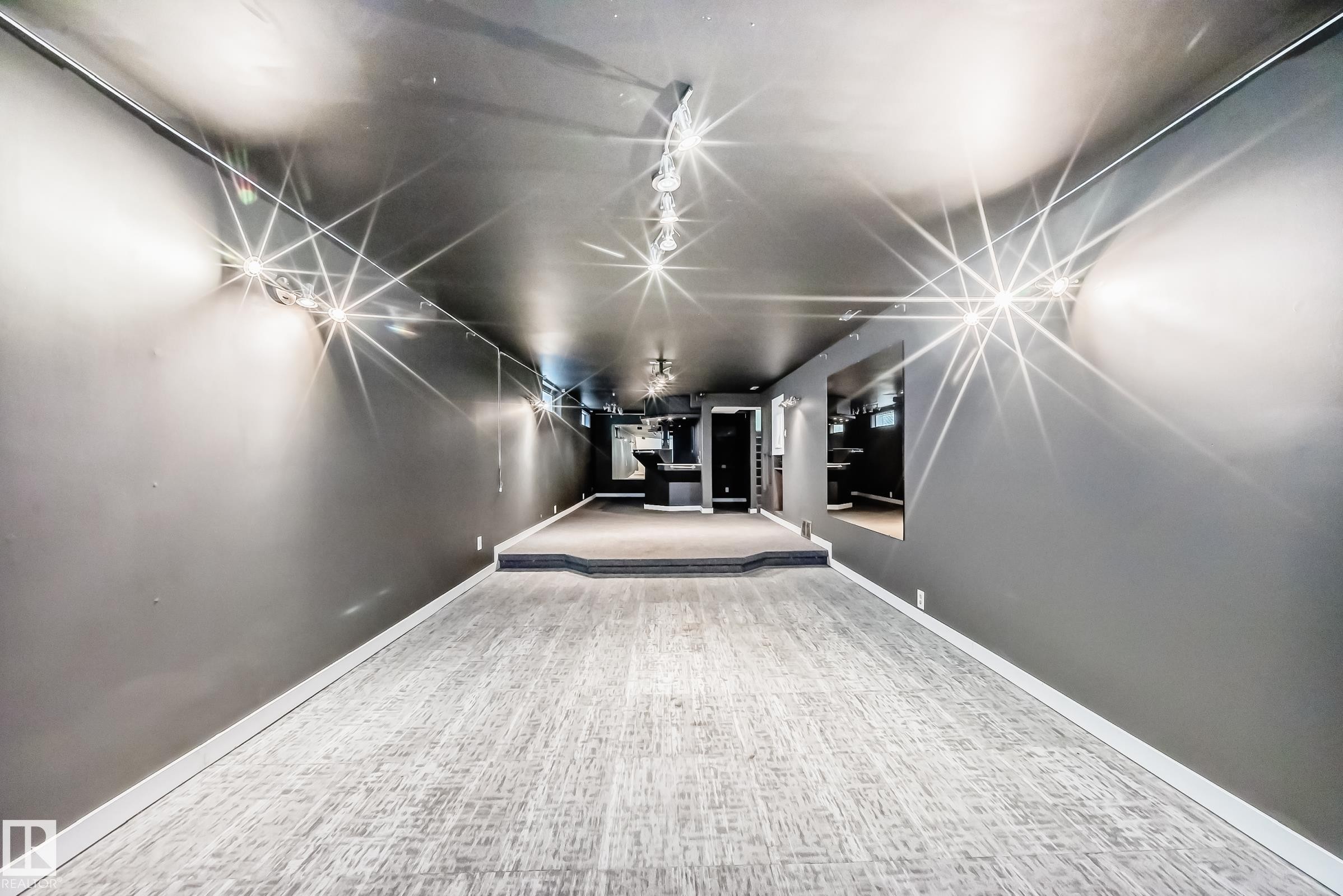 Spacious open room featuring gray walls, dark ceiling, recessed lighting, and light-toned carpet flooring - 5204 112 Avenue Nw, Edmonton, AB - Indoor Photo Showing Other Room