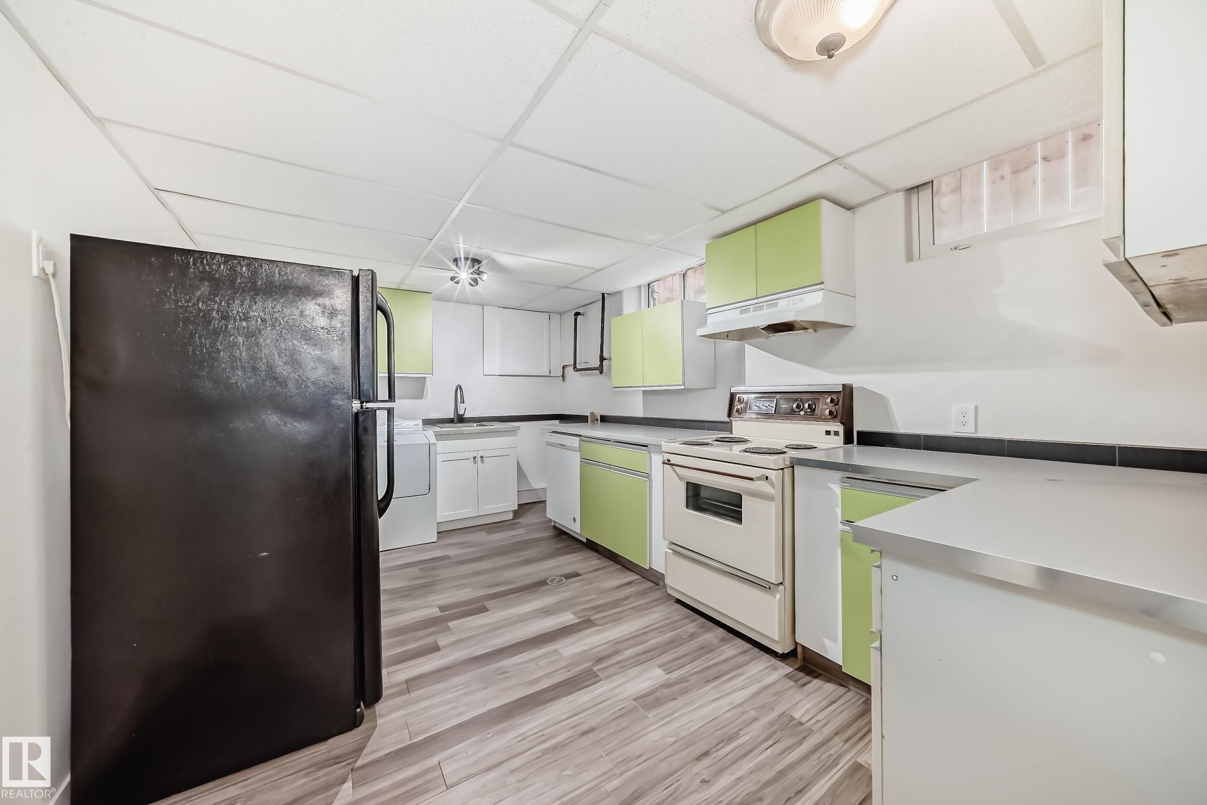 Kitchen featuring wood-finish flooring, light green cabinetry, white appliances, and gray countertops - 5204 112 Avenue Nw, Edmonton, AB - Indoor Photo Showing Kitchen