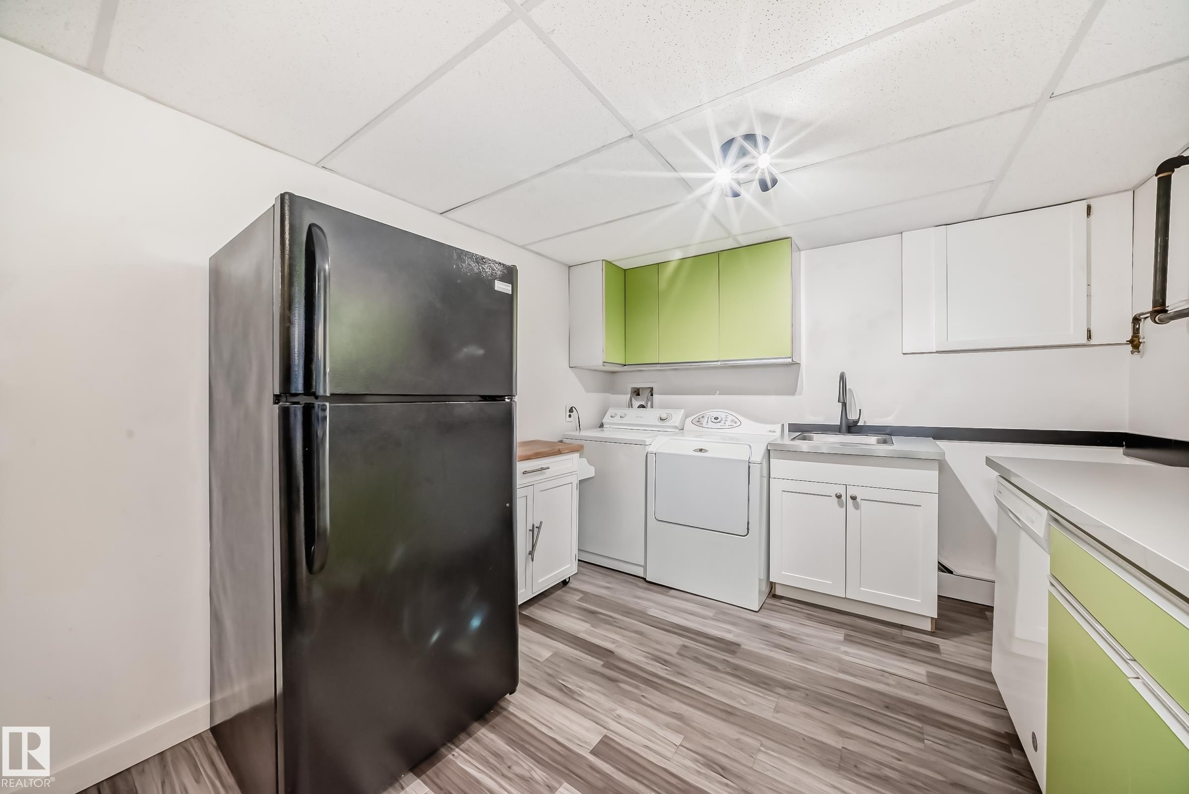 Utility room featuring wood-finish flooring, white walls, and a drop ceiling - 5204 112 Avenue Nw, Edmonton, AB - Indoor Photo Showing Laundry Room