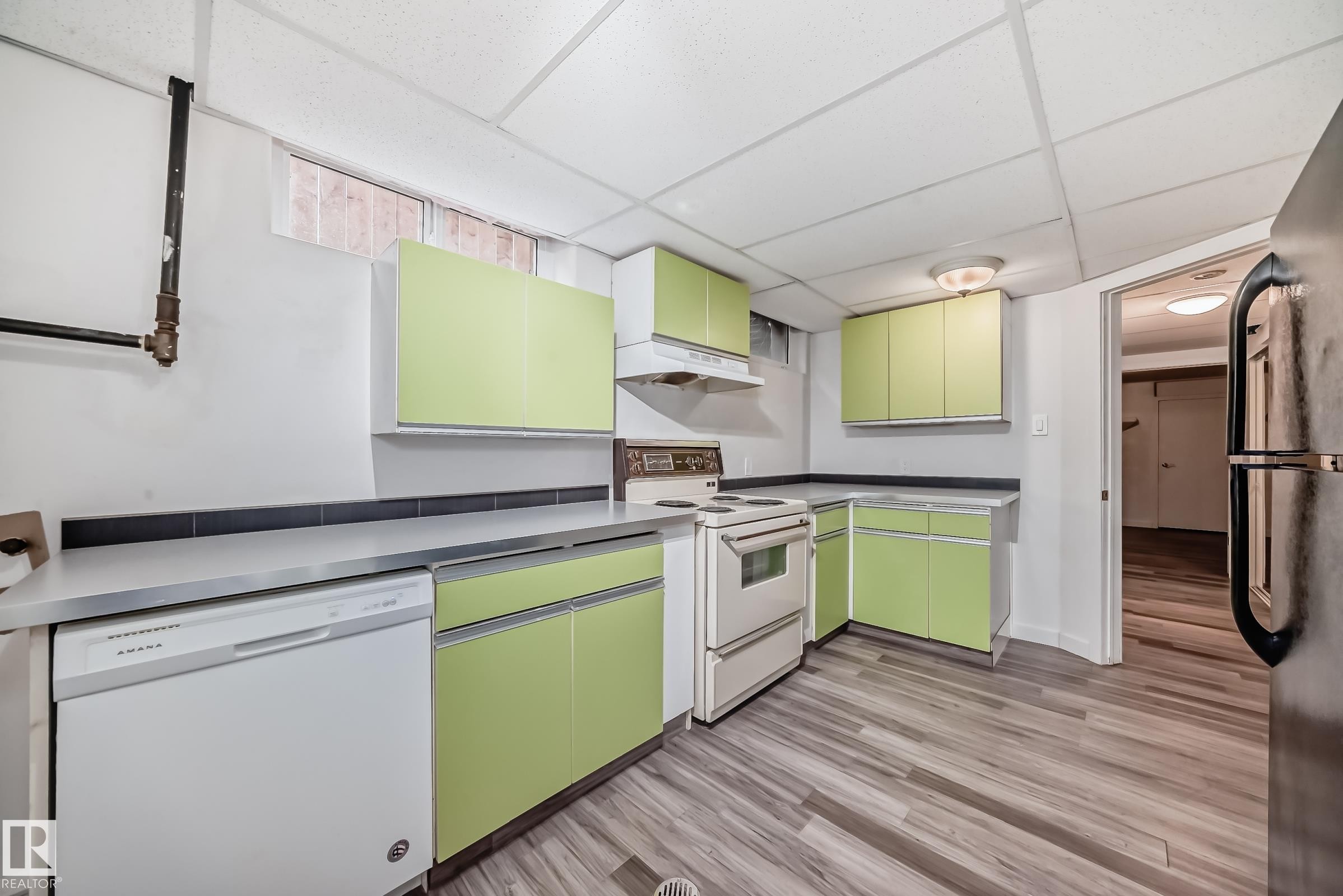 Kitchen featuring wood-finish flooring, light green cabinetry, and white appliances - 5204 112 Avenue Nw, Edmonton, AB - Indoor Photo Showing Kitchen