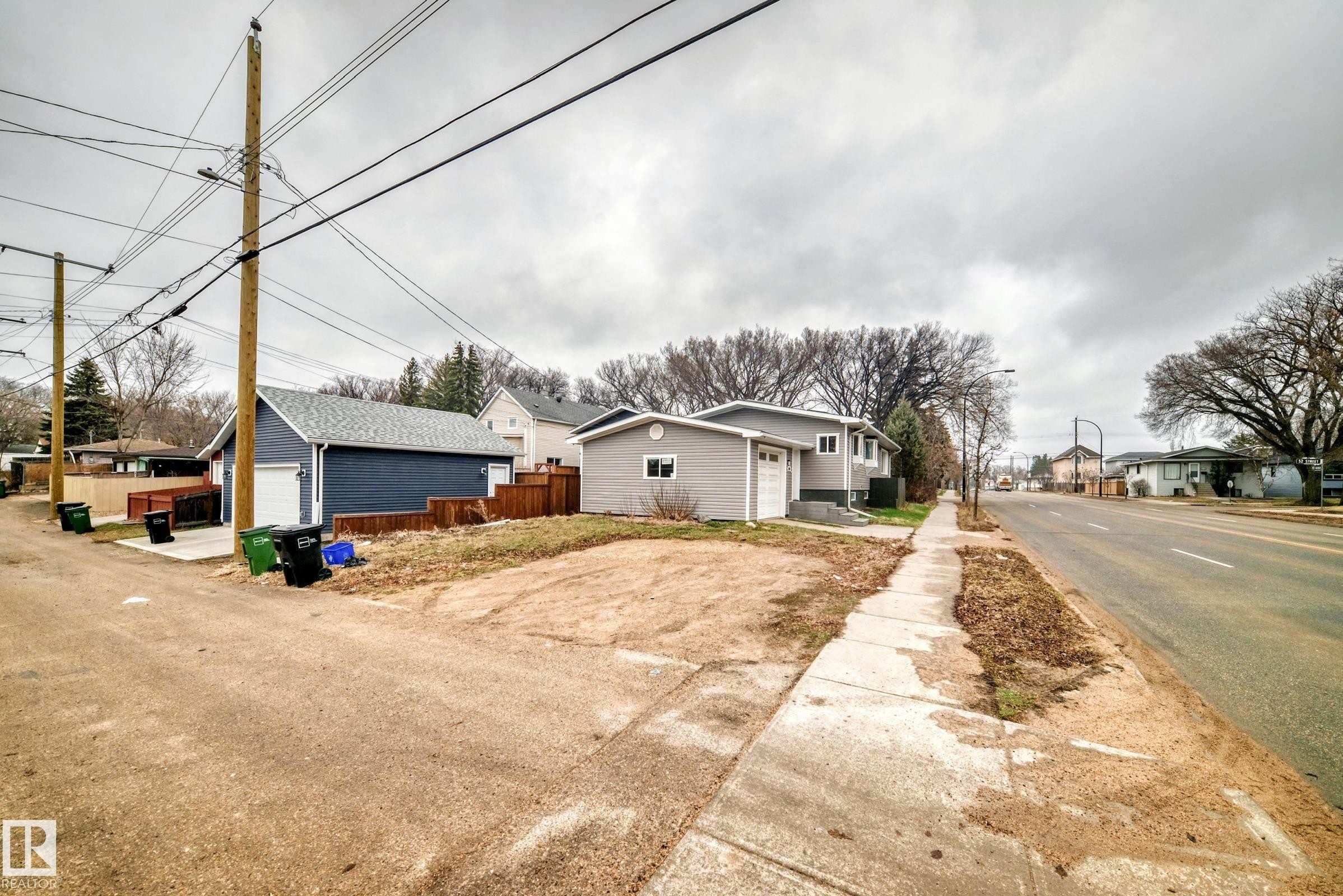 Property featuring a detached garage with a white overhead door and a separate single-car garage - 5204 112 Avenue Nw, Edmonton, AB - Outdoor
