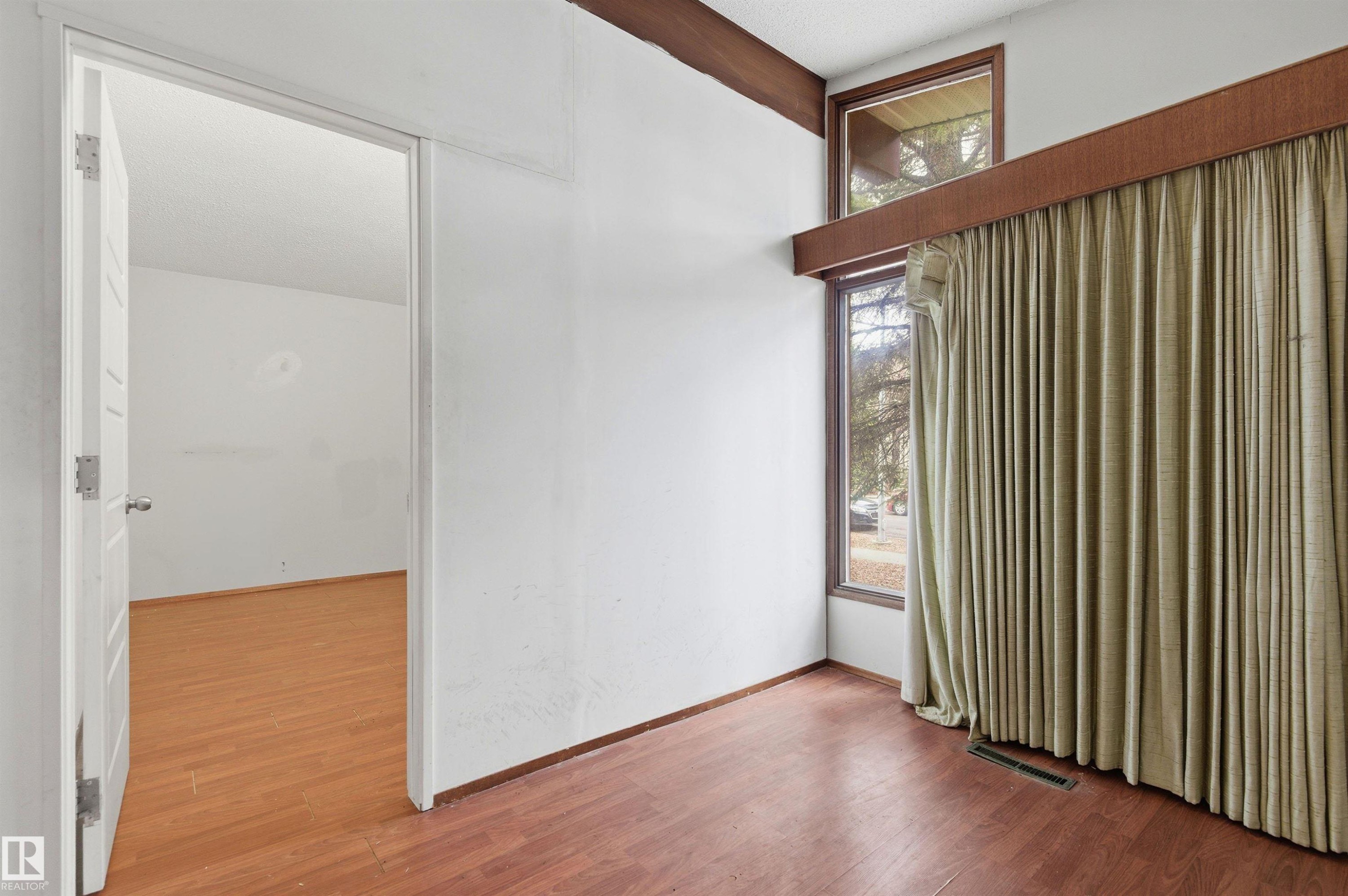 Room featuring wood-finish flooring, white walls, and a recessed ceiling vent - 11211 77 Avenue, Edmonton, AB - Indoor Photo Showing Other Room
