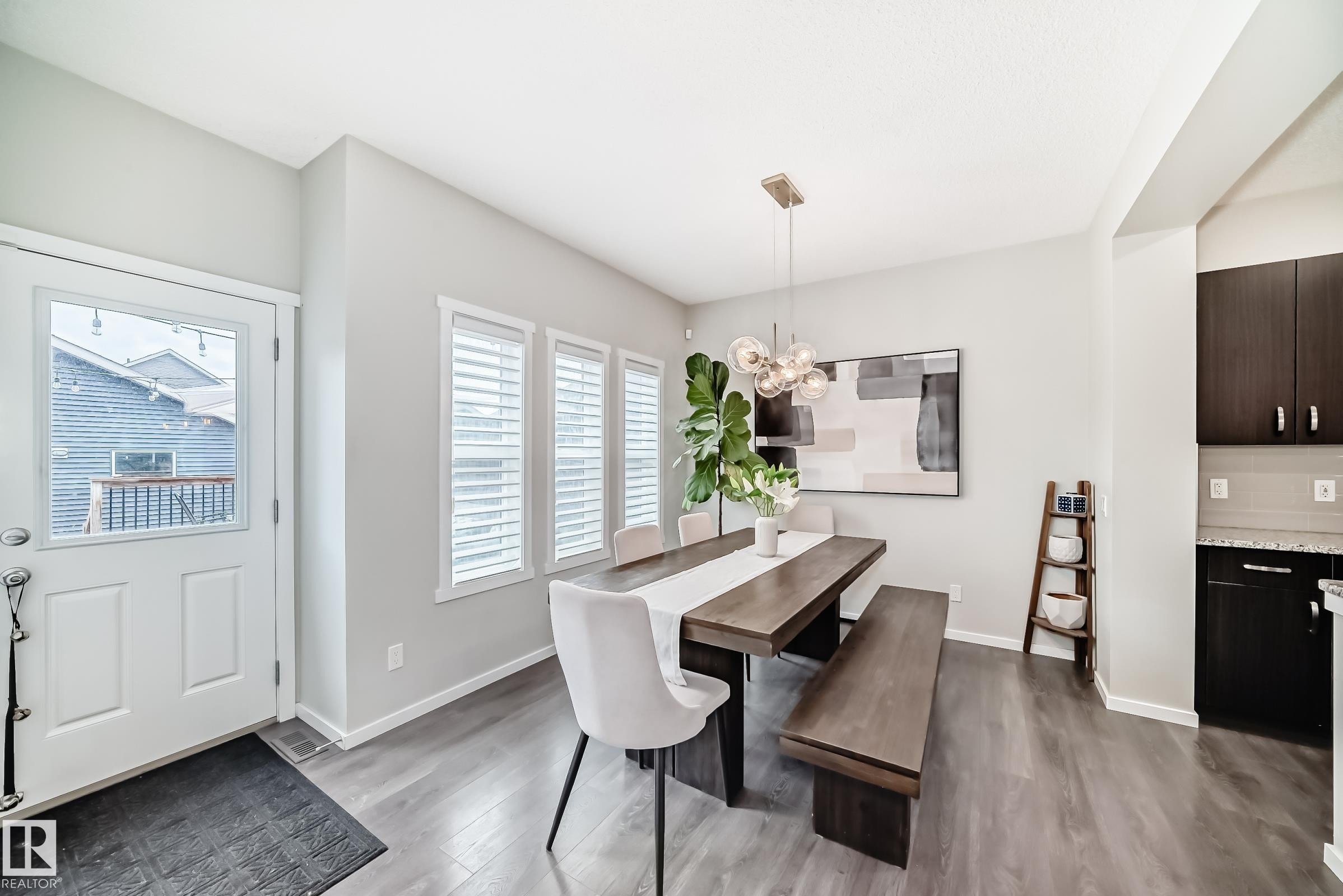 Dining area with wood-finish flooring and a contemporary chandelier - 3278 Cherry Crescent, Edmonton, AB - Indoor Photo Showing Dining Room