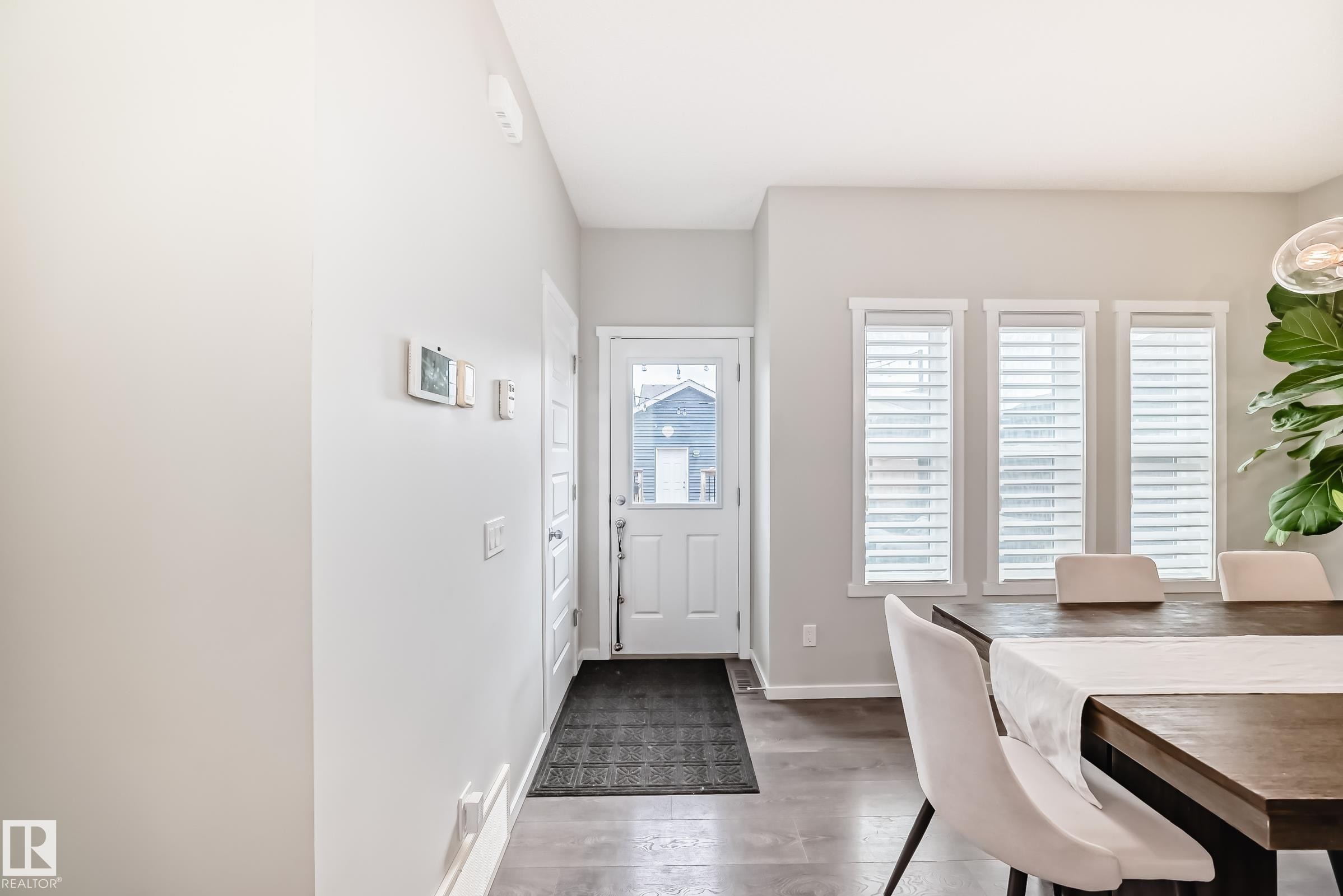 Entryway with light gray walls, tile flooring, and a white paneled door with glass insert - 3278 Cherry Crescent, Edmonton, AB - Indoor Photo Showing Dining Room