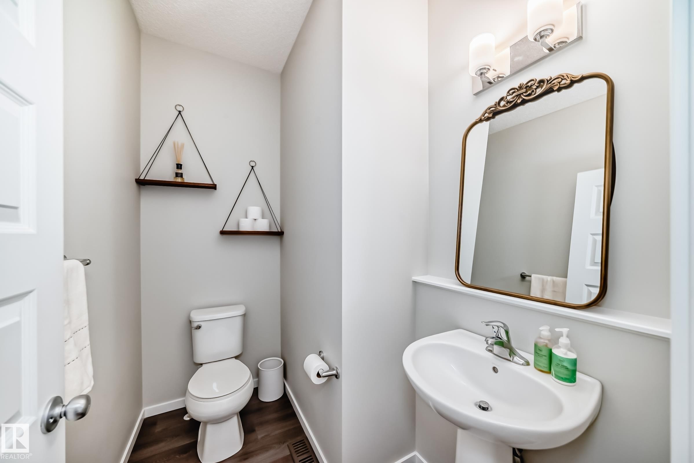 Pedestal sink with chrome faucet, framed mirror, and wall-mounted light fixture - 3278 Cherry Crescent, Edmonton, AB - Indoor Photo Showing Bathroom