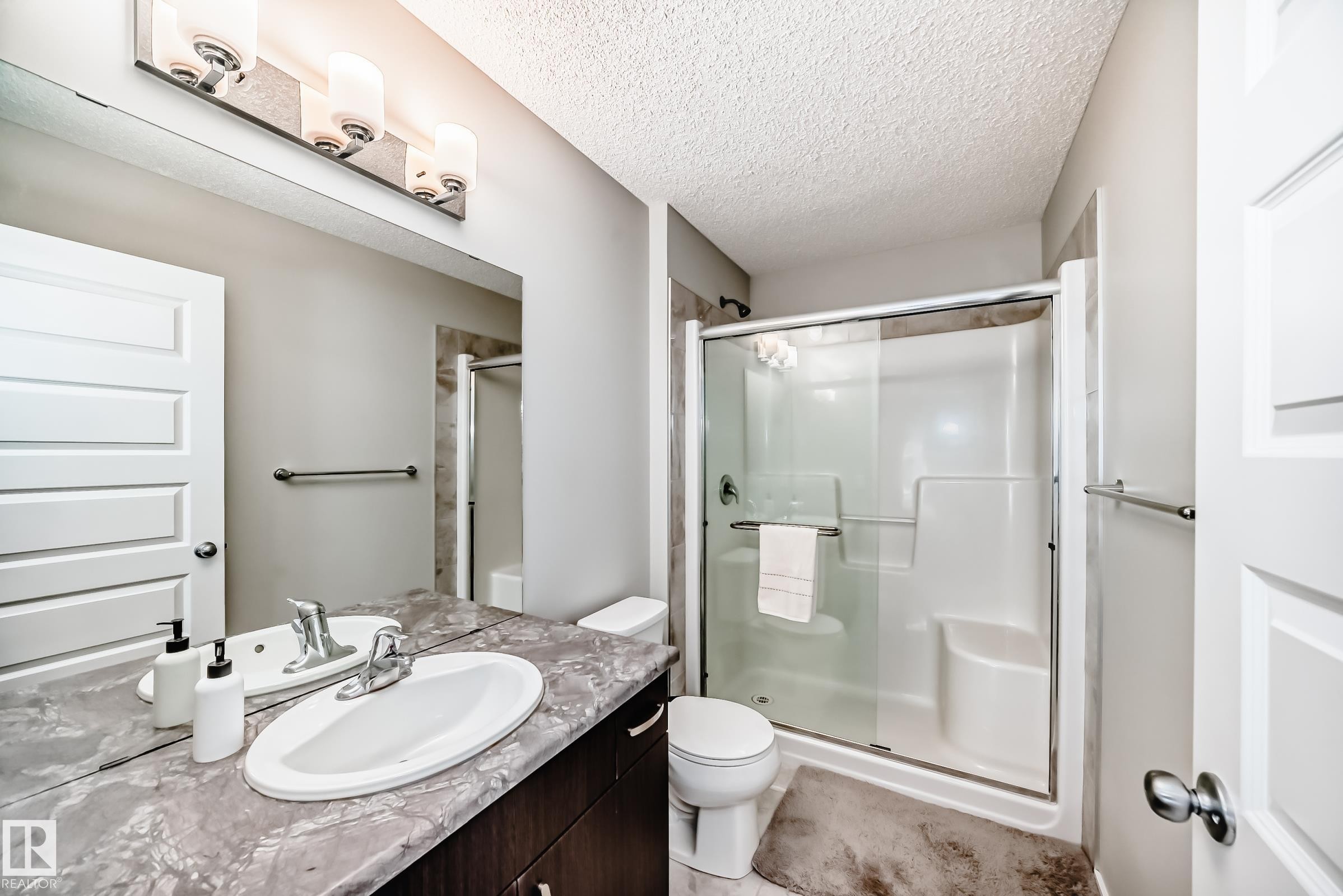 Bathroom featuring a vanity with a large mirror, oval undermount sink, and stone-finish countertop - 3278 Cherry Crescent, Edmonton, AB - Indoor Photo Showing Bathroom