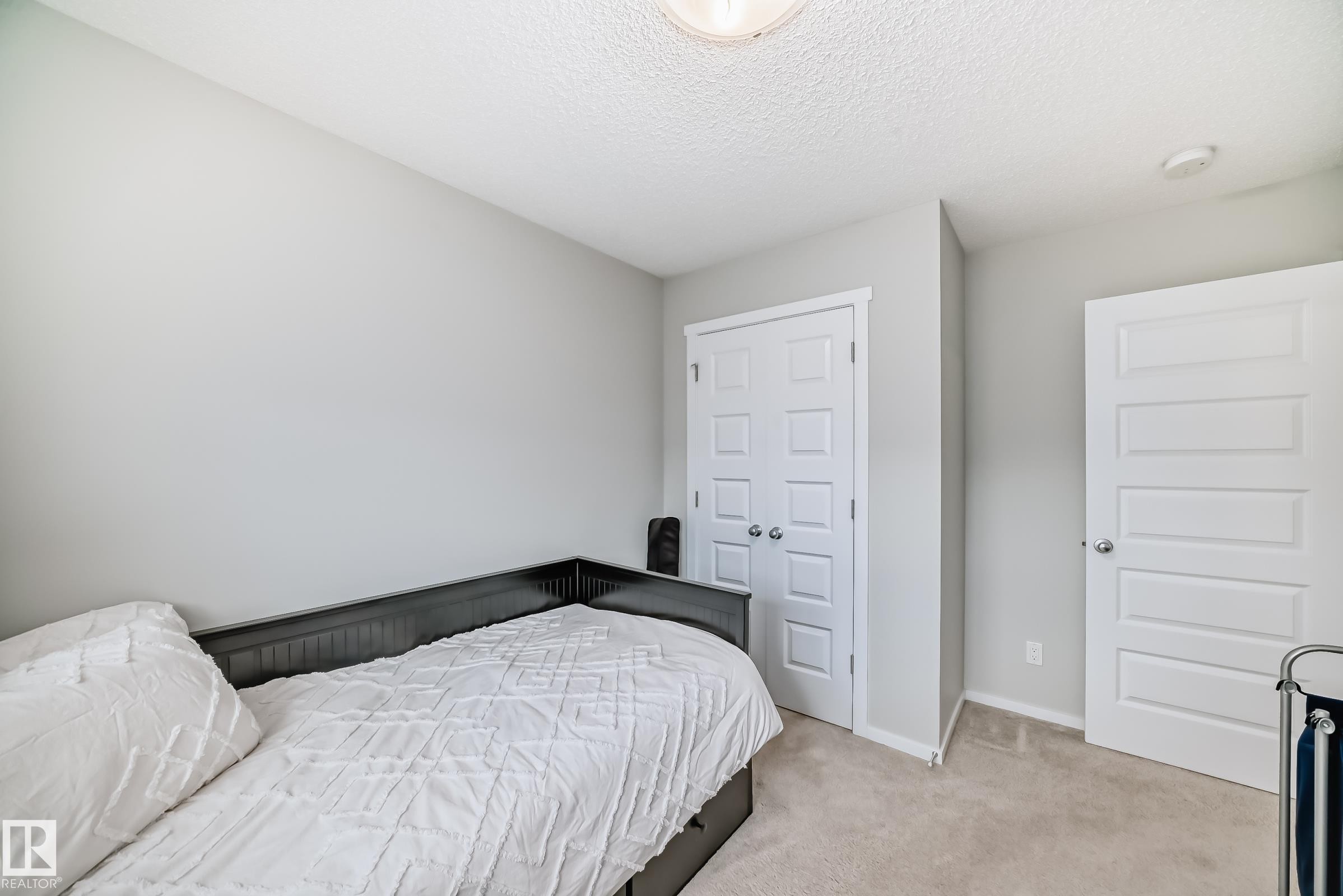 Neutral-toned room featuring a light-colored carpet, painted walls, and a textured ceiling - 3278 Cherry Crescent, Edmonton, AB - Indoor Photo Showing Bedroom