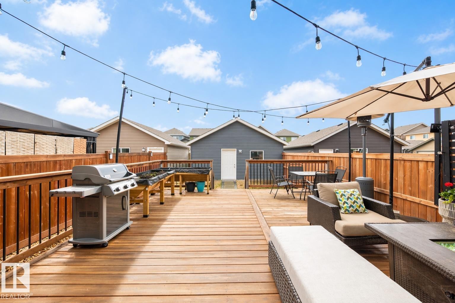 Expansive wood-finish deck with perimeter railing, string lighting, and privacy fencing - 3278 Cherry Crescent, Edmonton, AB - Outdoor With Deck Patio Veranda With Exterior