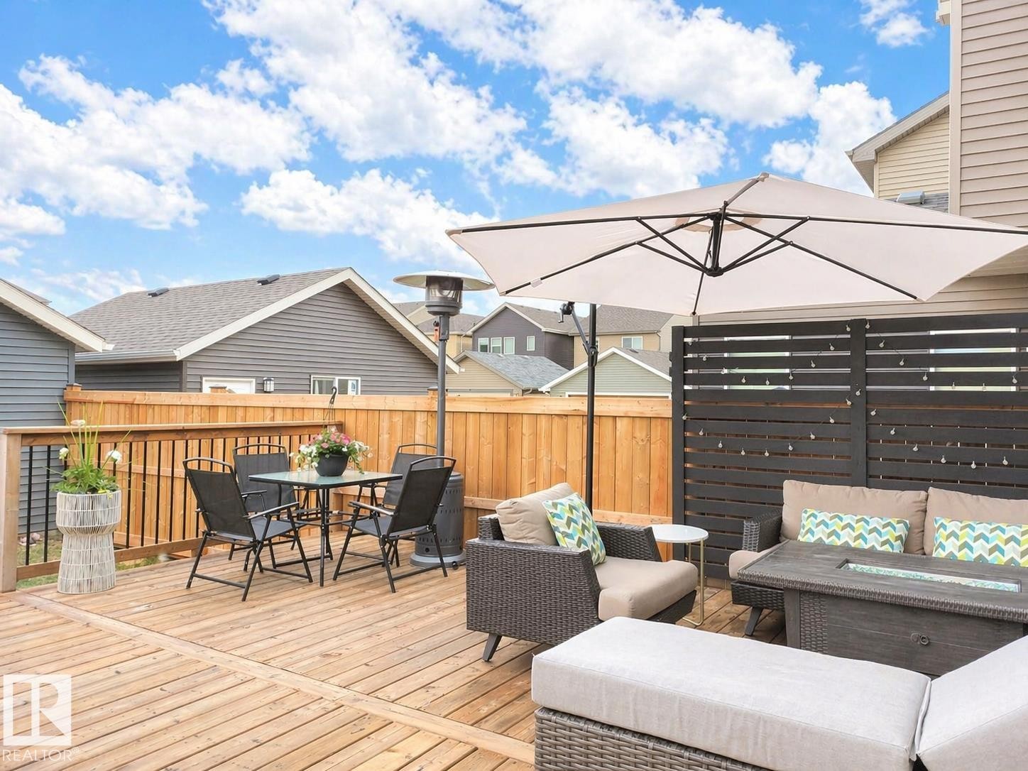 Expansive wood deck with a full-height wood fence, black privacy screen, and an attached umbrella - 3278 Cherry Crescent, Edmonton, AB - Outdoor With Deck Patio Veranda With Exterior