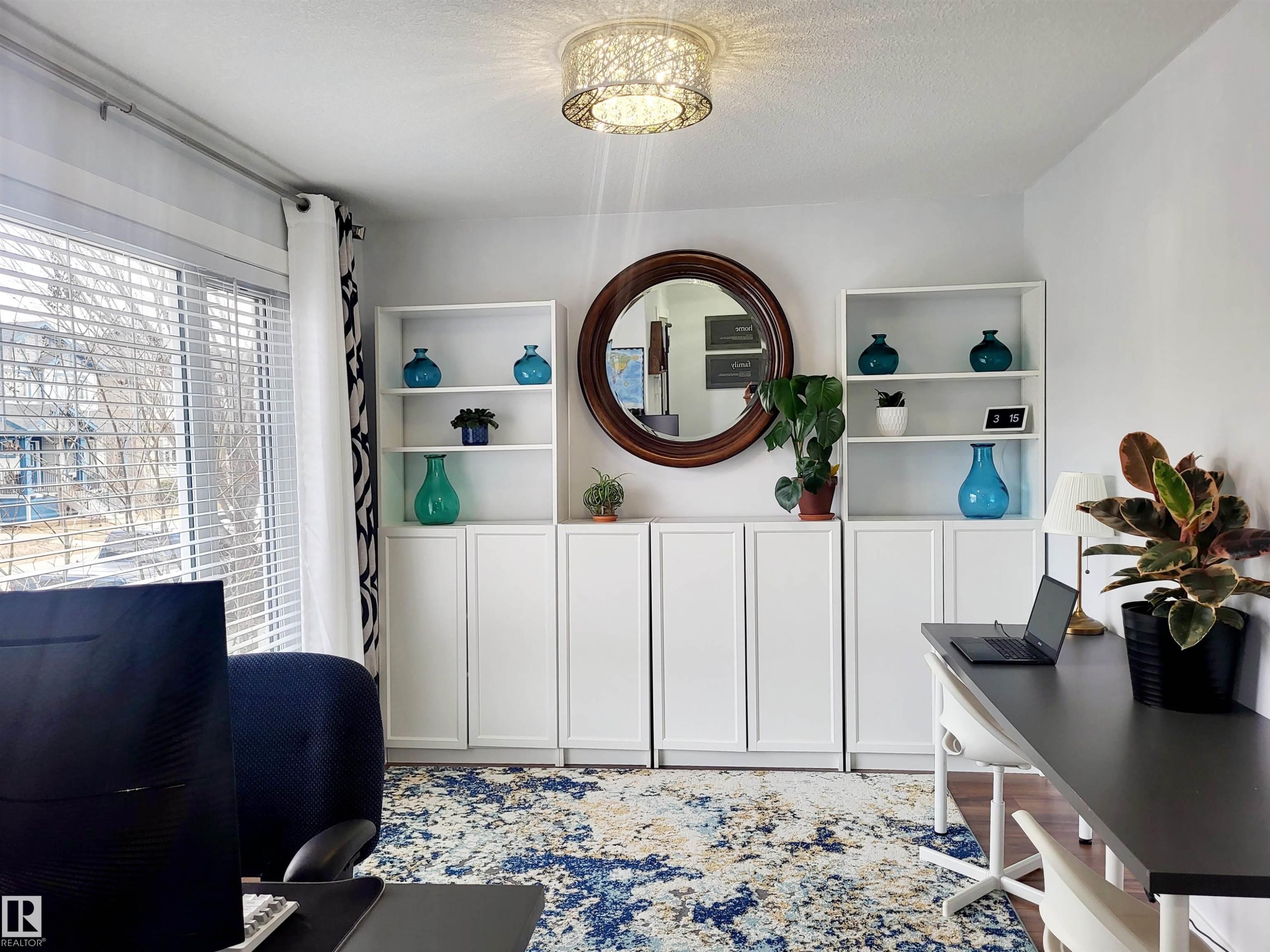 Bright interior space featuring a window with white blinds, a contemporary ceiling light fixture, and built-in white cabinetry with open shelving - 144 Kirpatrick Way, Leduc, AB - Indoor Photo Showing Other Room