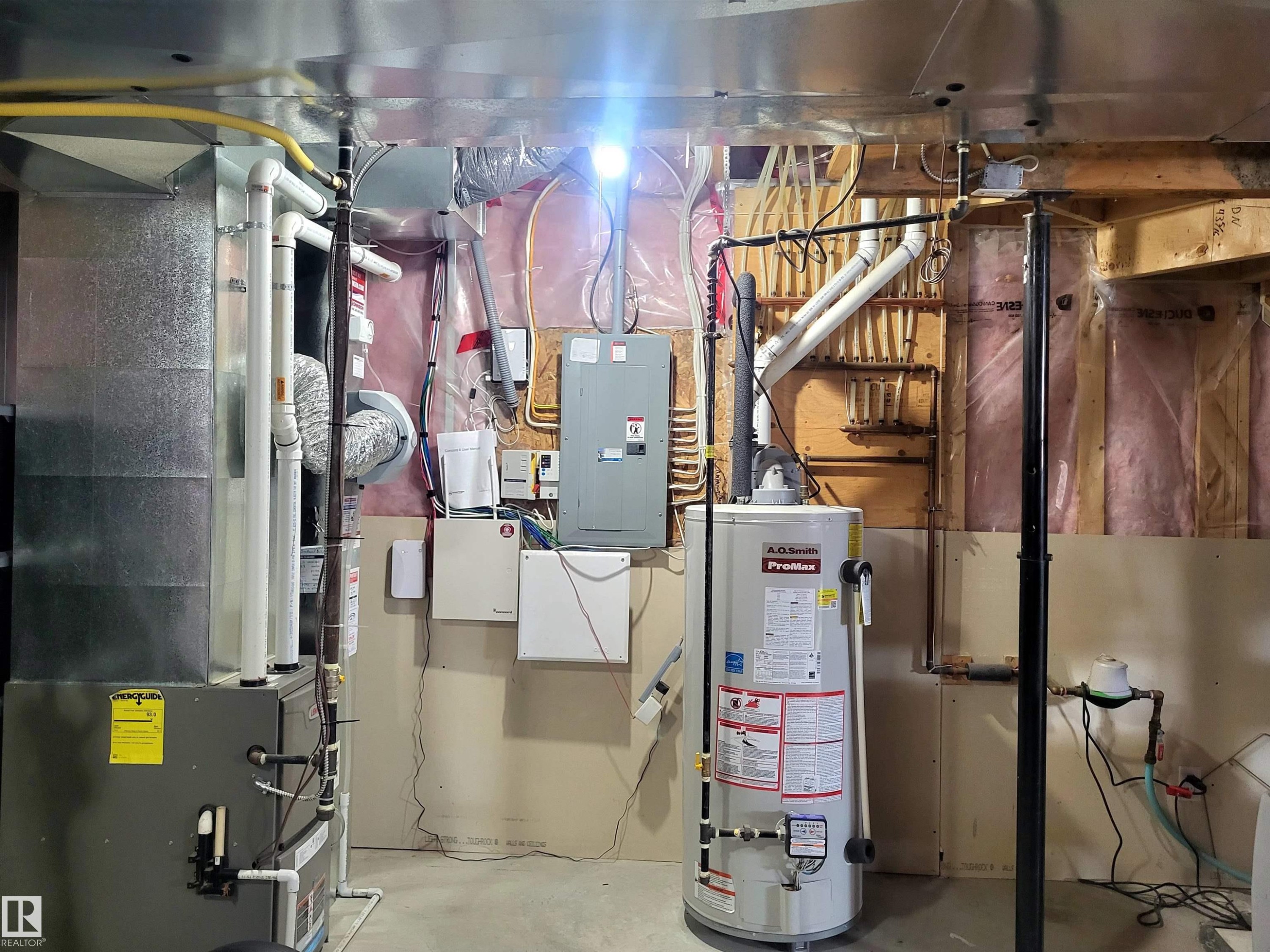 Utility room featuring a water heater, furnace, electrical panel, and exposed ductwork - 144 Kirpatrick Way, Leduc, AB - Indoor Photo Showing Basement