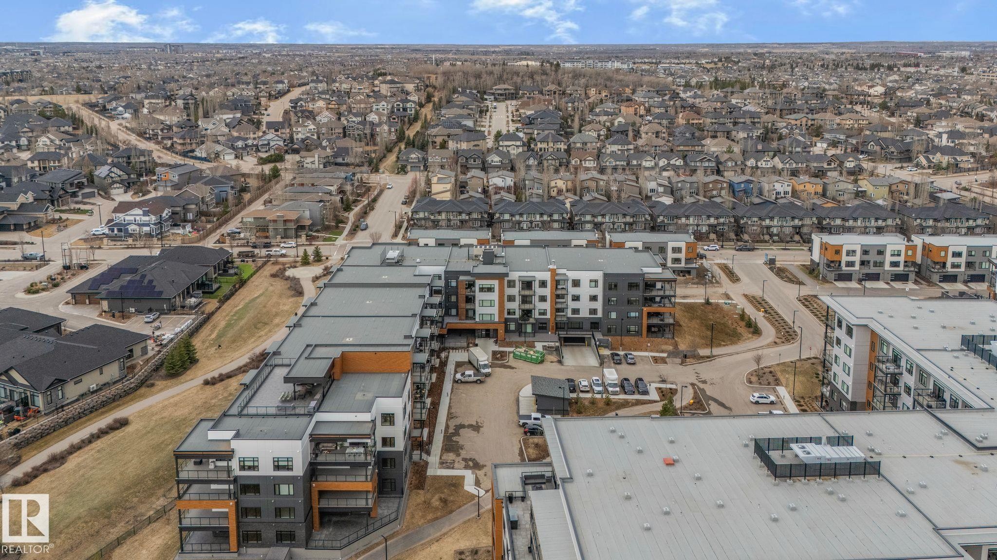 Contemporary multi-story building featuring balconies and a flat roofline - 202 7459 May Common, Edmonton, AB - Outdoor With View