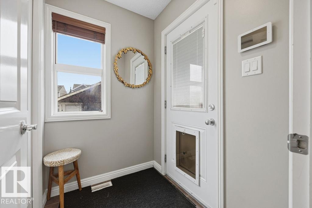 Extra space back entry mudroom, off kitchen. Entryway featuring light gray walls, white trim, and a window with a woven wood-finish blind - 1613 Kerr Road, Edmonton, AB - Indoor Photo Showing Other Room
