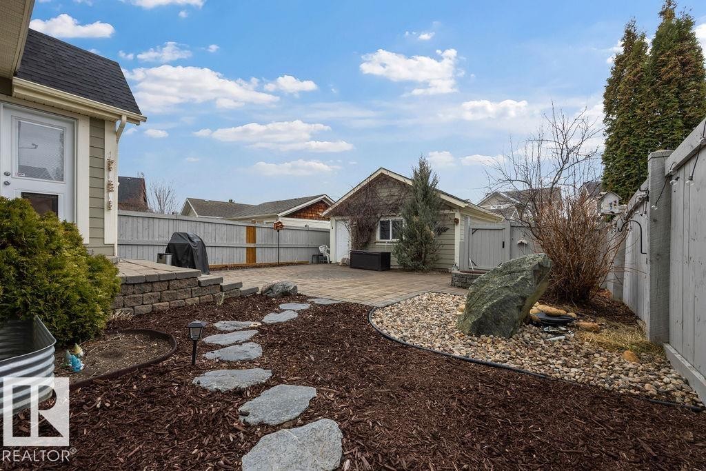 Landscaped backyard featuring a paver patio and stepping stone pathway - 1613 Kerr Road, Edmonton, AB - Outdoor