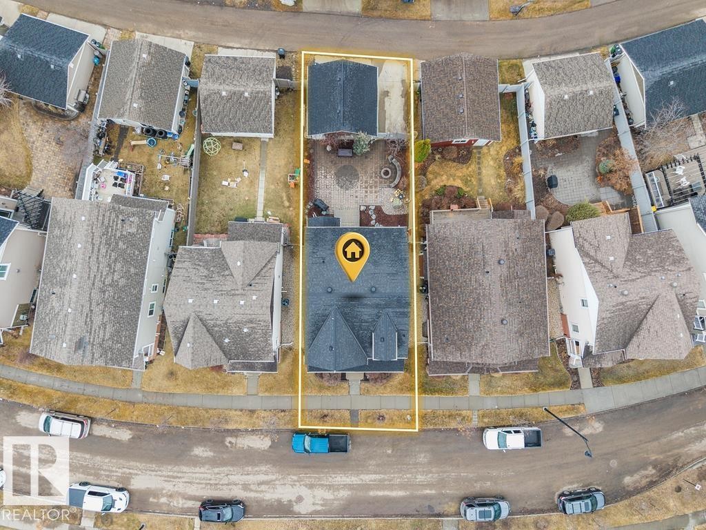 Property with a dark shingle roof and an elongated backyard featuring a patio area - 1613 Kerr Road, Edmonton, AB -