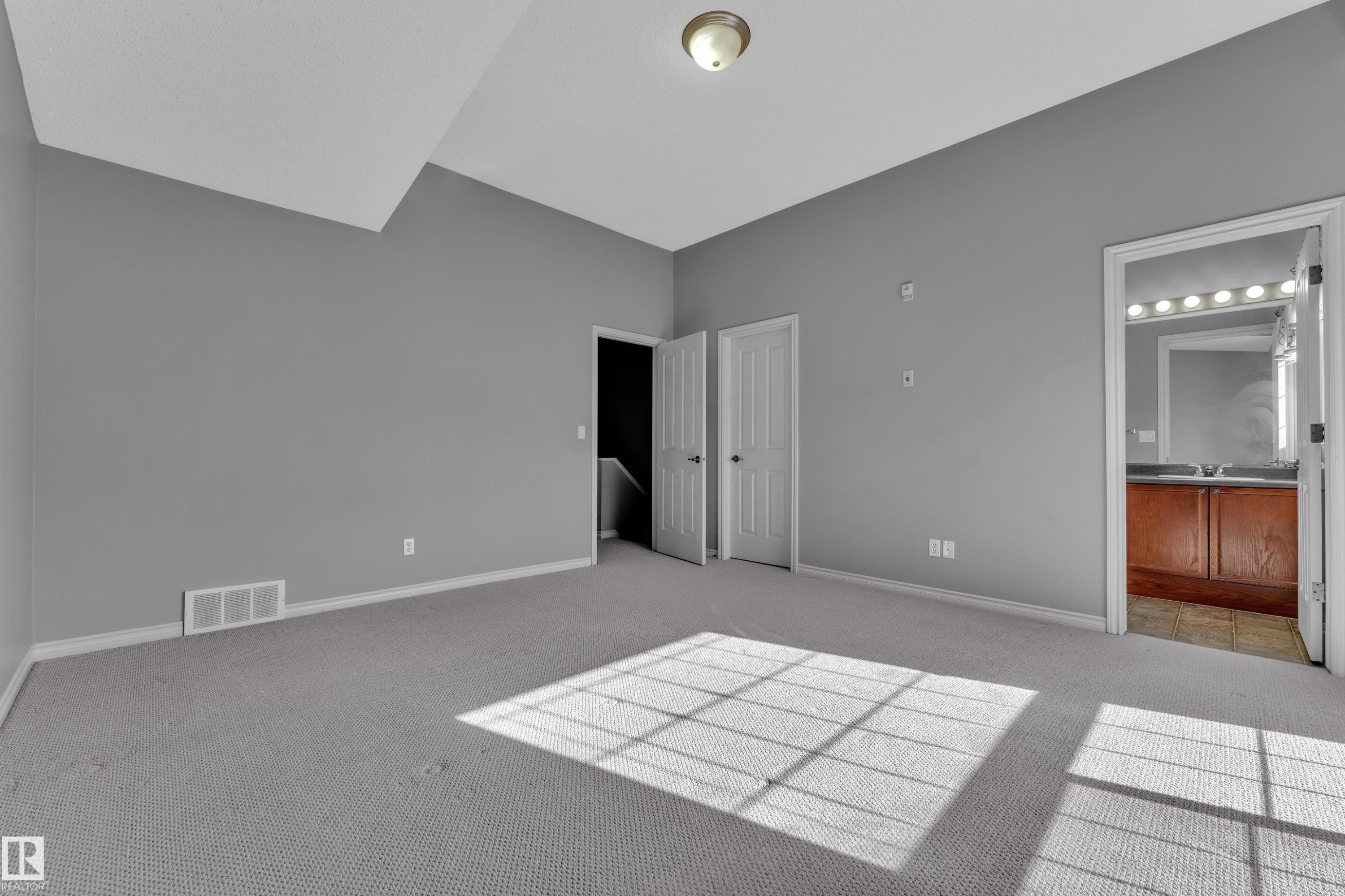 Carpeted interior room featuring gray walls and white trim - 110 13825 155, Edmonton, AB - Indoor Photo Showing Other Room