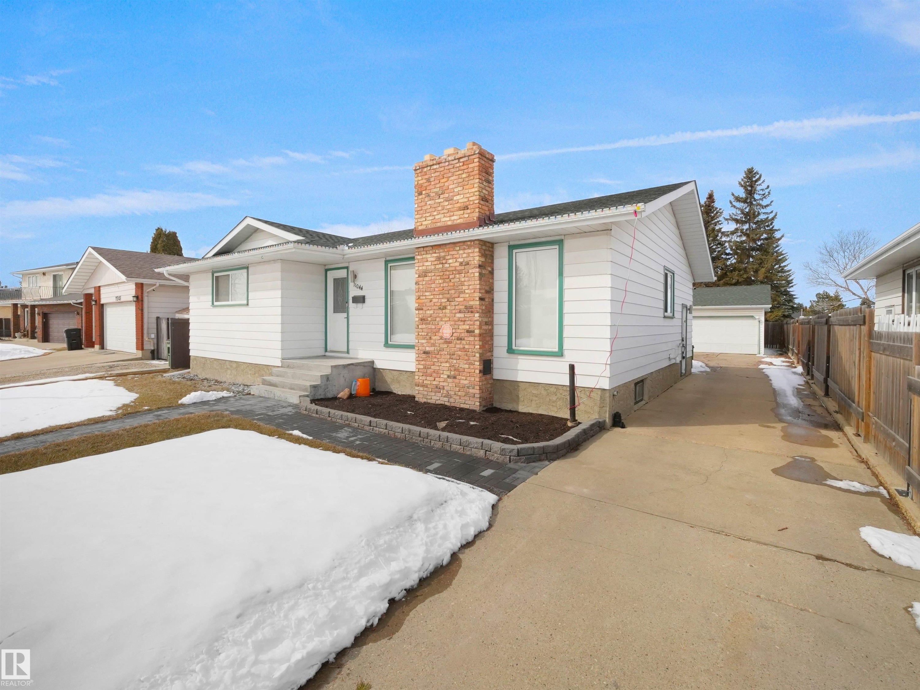 White siding residence featuring a prominent brick chimney and a light-colored front door - 11044 166 Avenue, Edmonton, AB - Outdoor