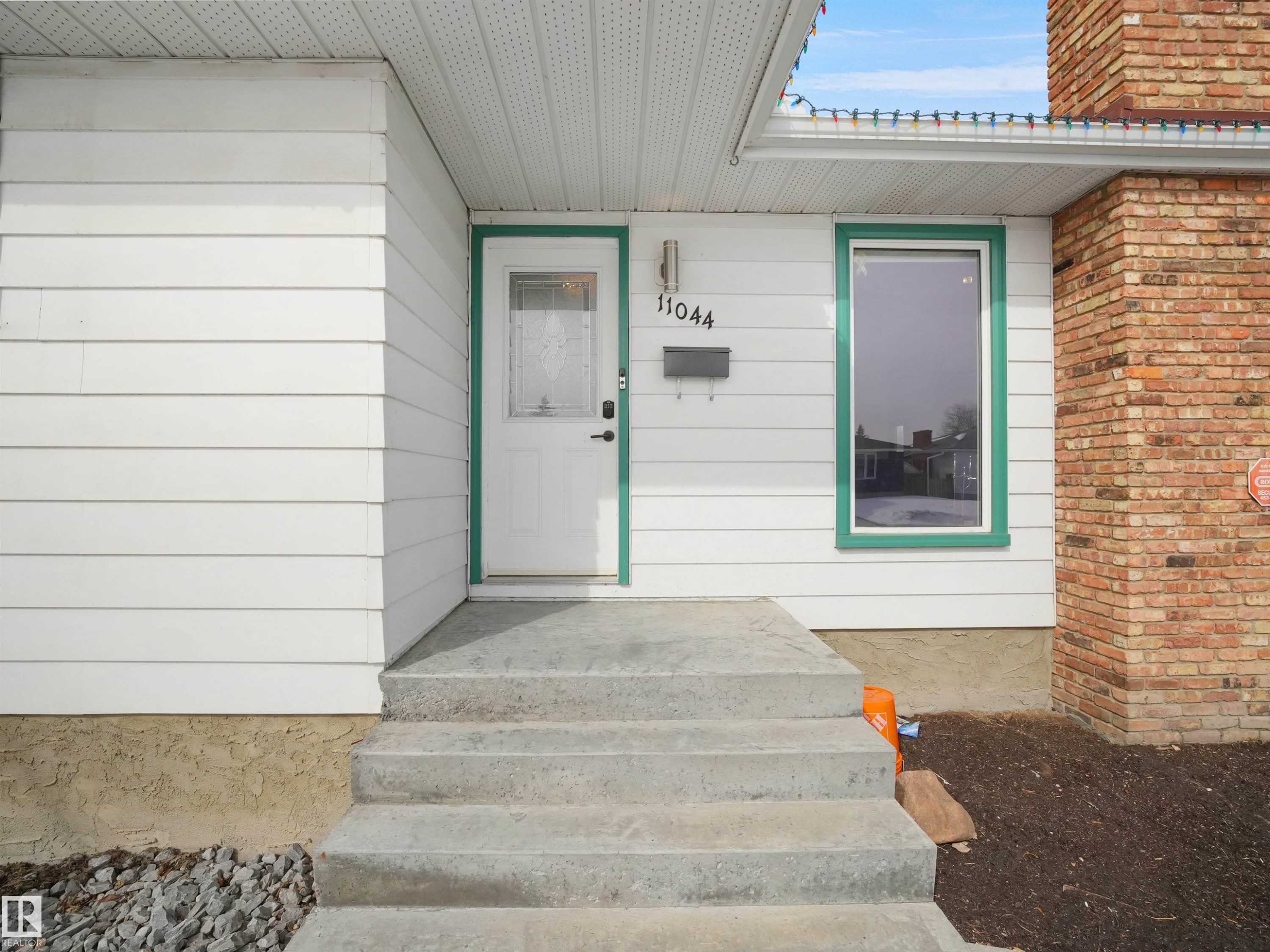 White horizontal siding exterior with a brick chimney accent - 11044 166 Avenue, Edmonton, AB - Outdoor With Exterior