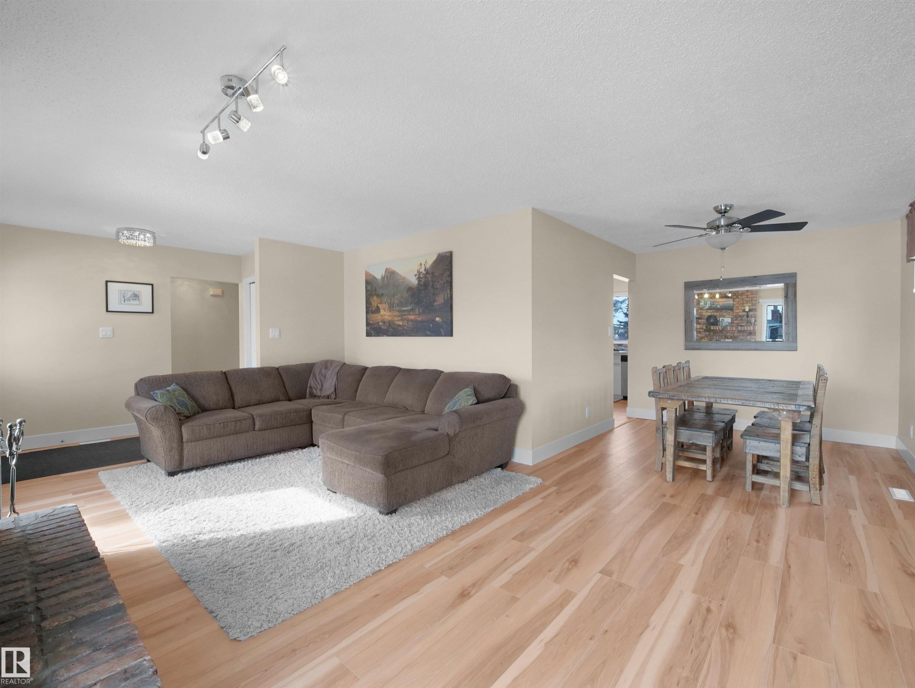 Open-concept living and dining area featuring wood-finish flooring, neutral wall tones, and recessed lighting - 11044 166 Avenue, Edmonton, AB - Indoor Photo Showing Living Room