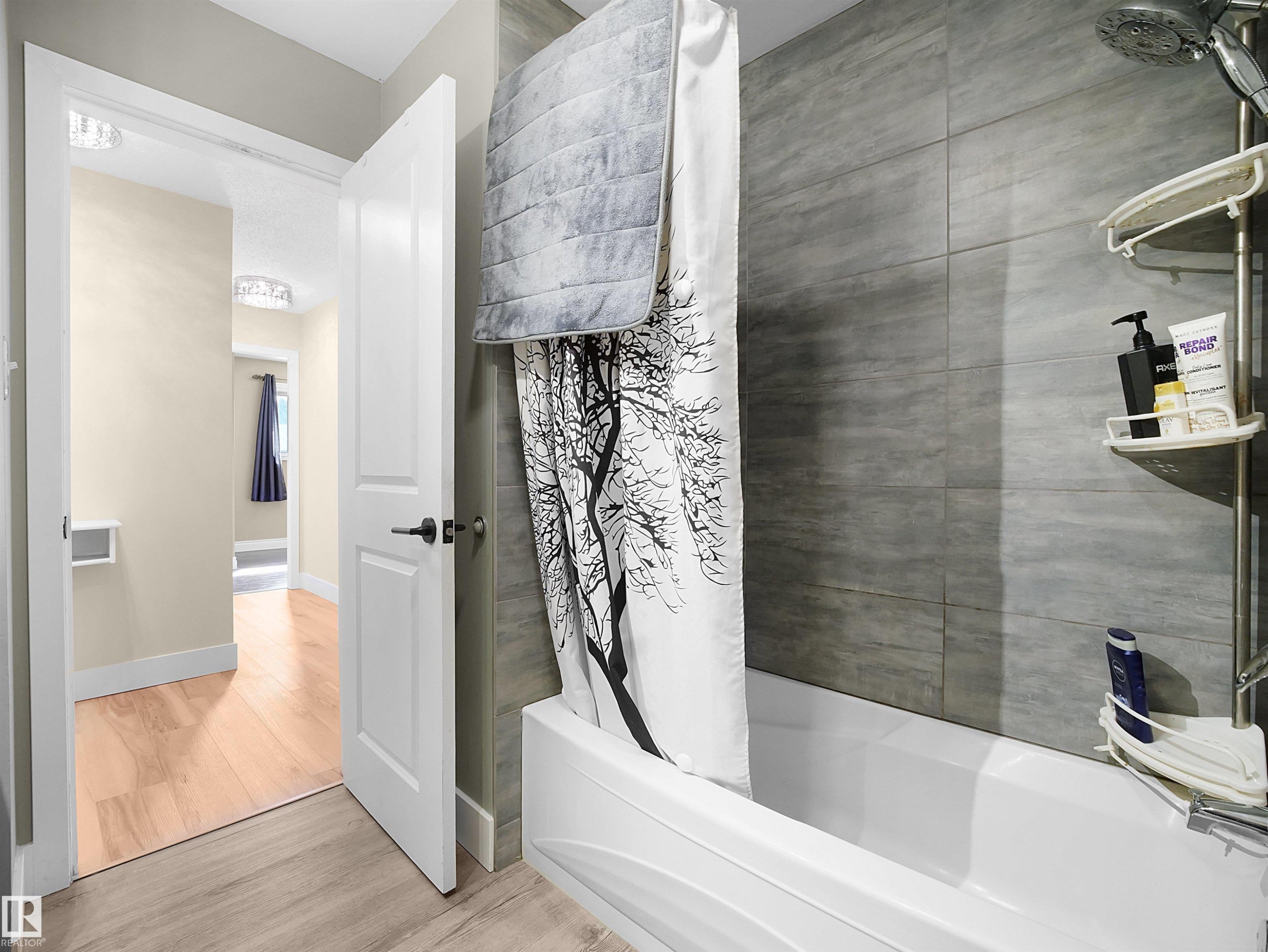 White bathtub with a gray tiled shower surround - 11044 166 Avenue, Edmonton, AB - Indoor Photo Showing Bathroom