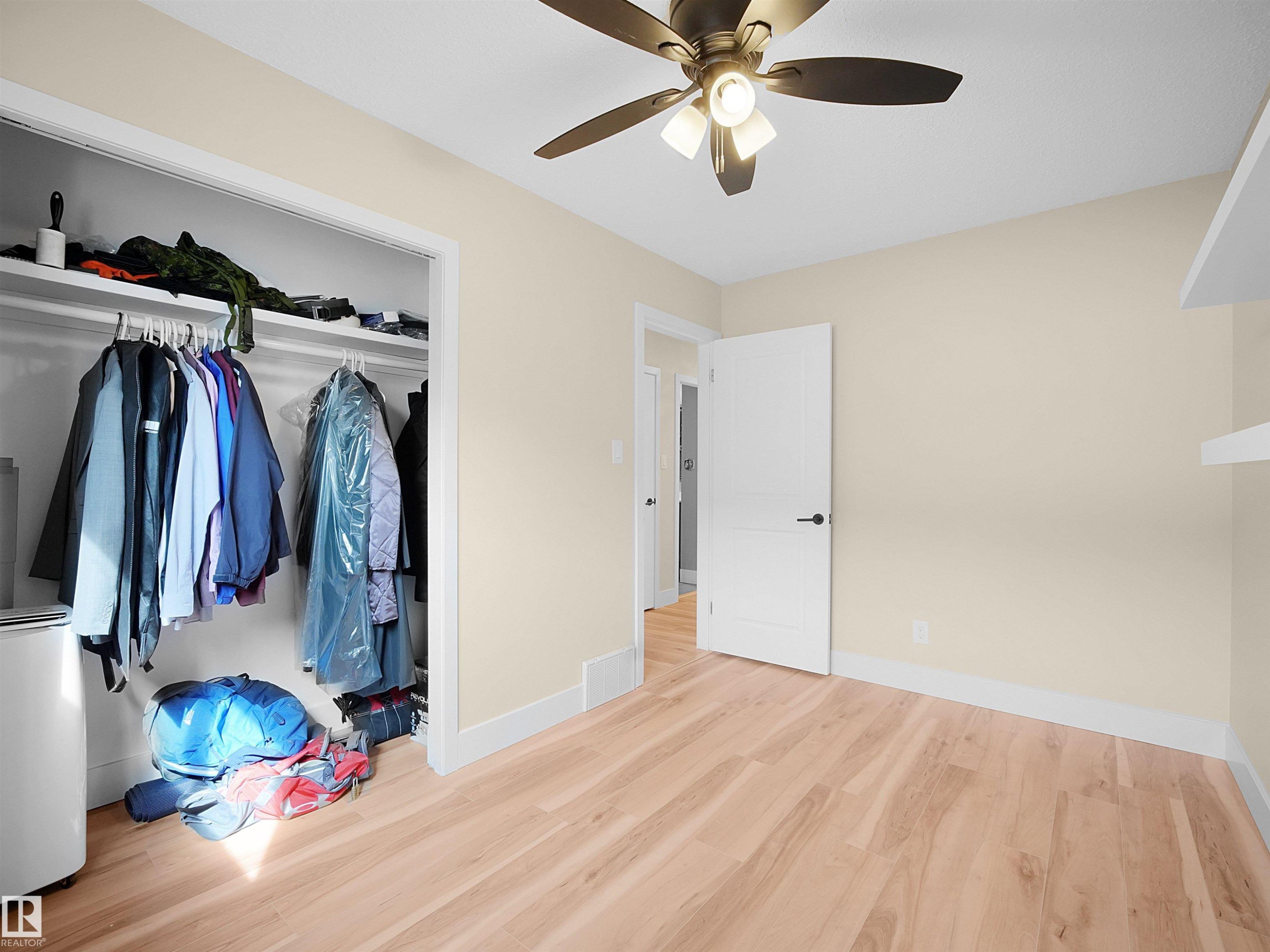 Light wood-finish flooring complements neutral wall tones and white baseboards - 11044 166 Avenue, Edmonton, AB - Indoor