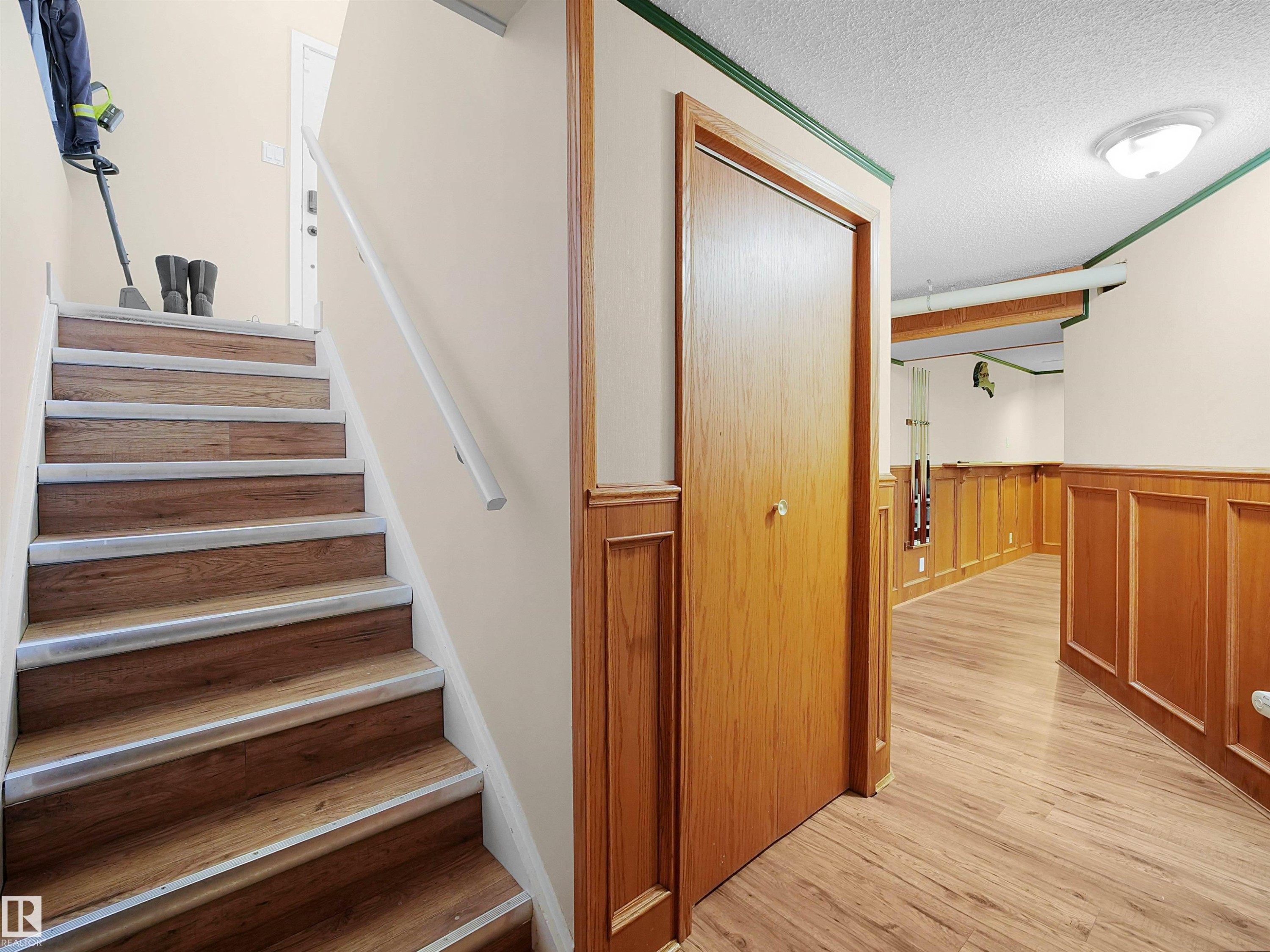 Wood-finish flooring throughout the lower level and stairs - 11044 166 Avenue, Edmonton, AB - Indoor Photo Showing Other Room