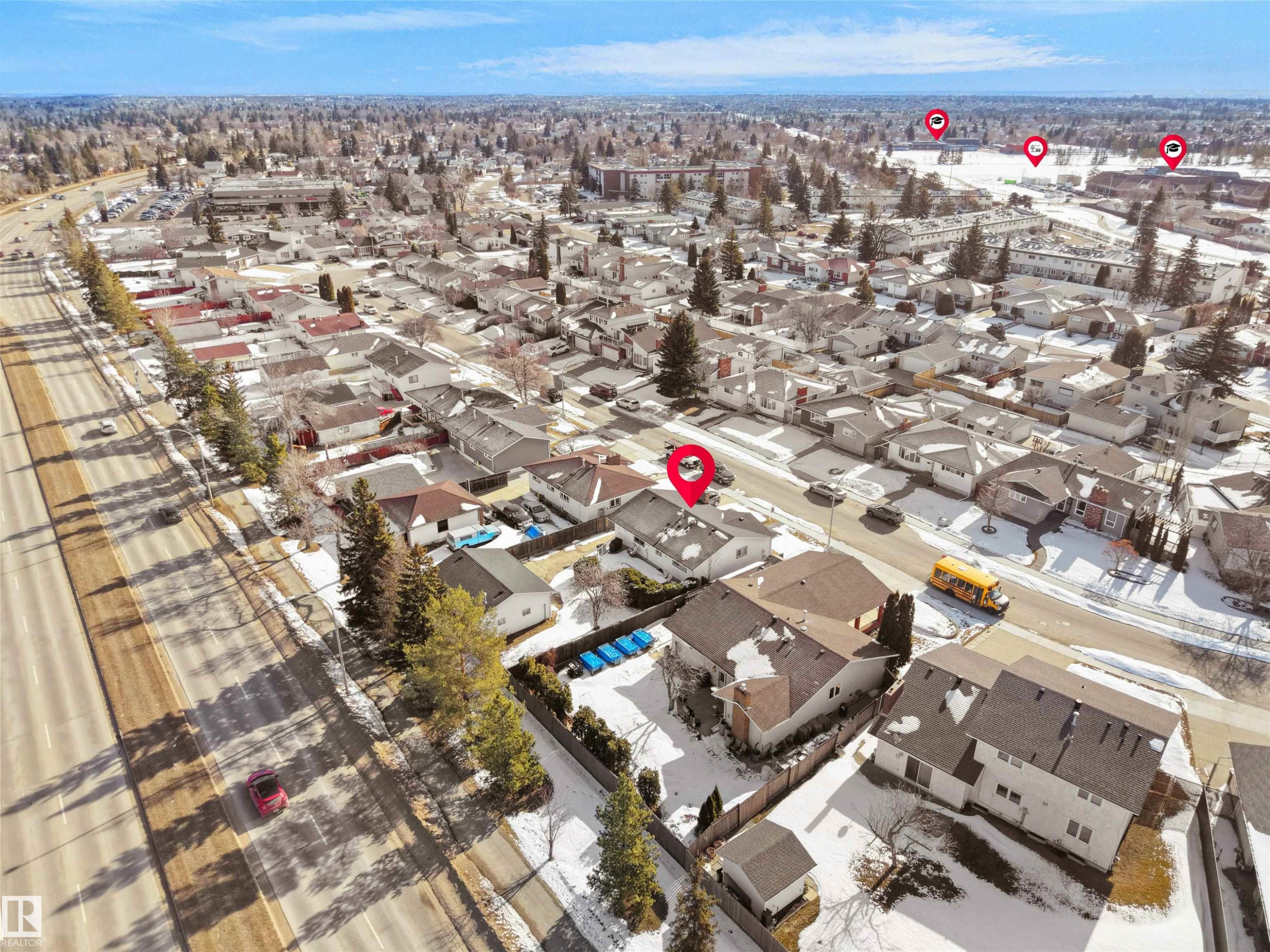 Residential neighborhood featuring single-story and multi-story homes, established trees, and a visible highway - 11044 166 Avenue, Edmonton, AB - Outdoor With View