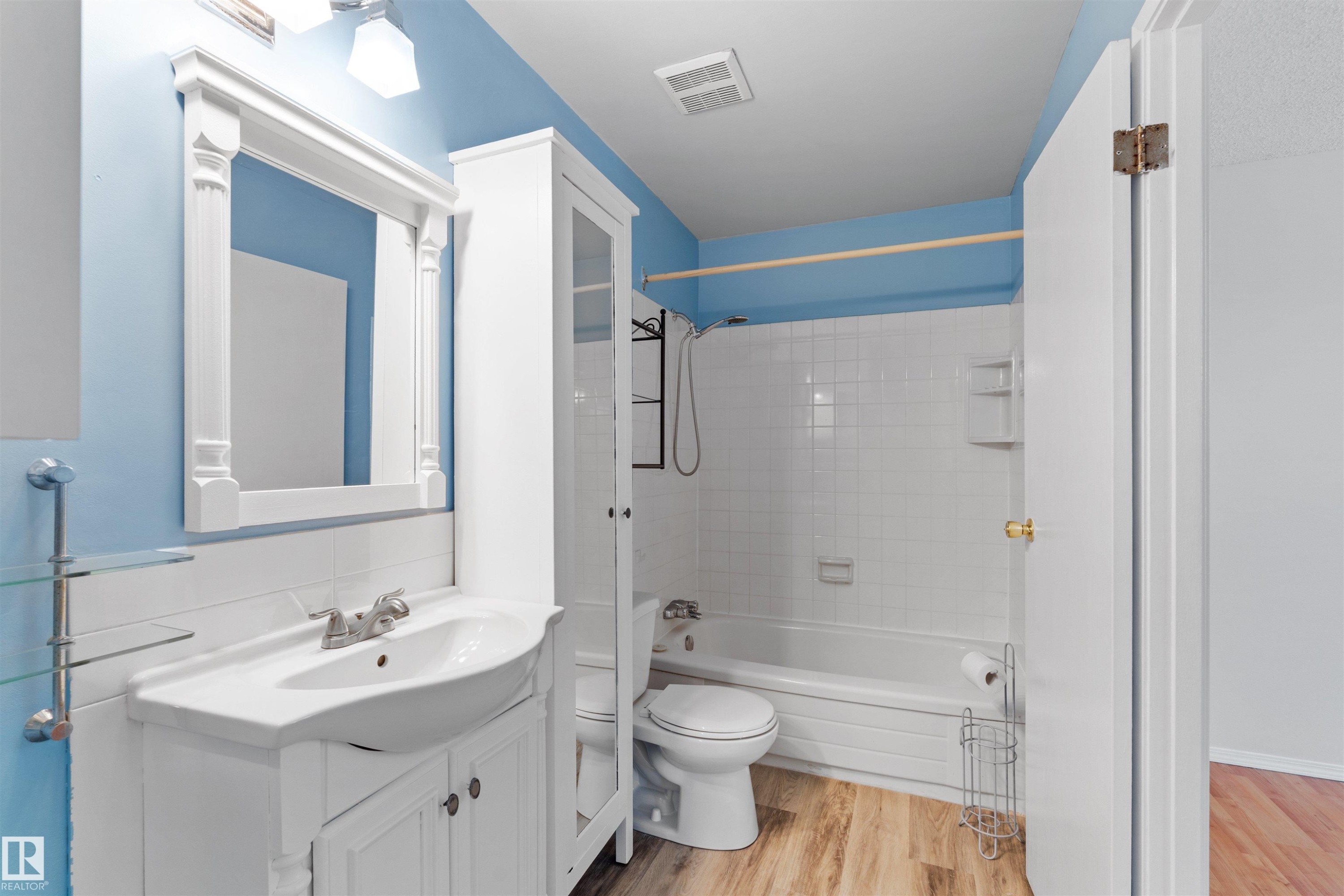 Bathroom featuring a white vanity with integrated sink, framed mirror, and chrome fixtures - 1116 Saddleback Road, Edmonton, AB - Indoor Photo Showing Bathroom