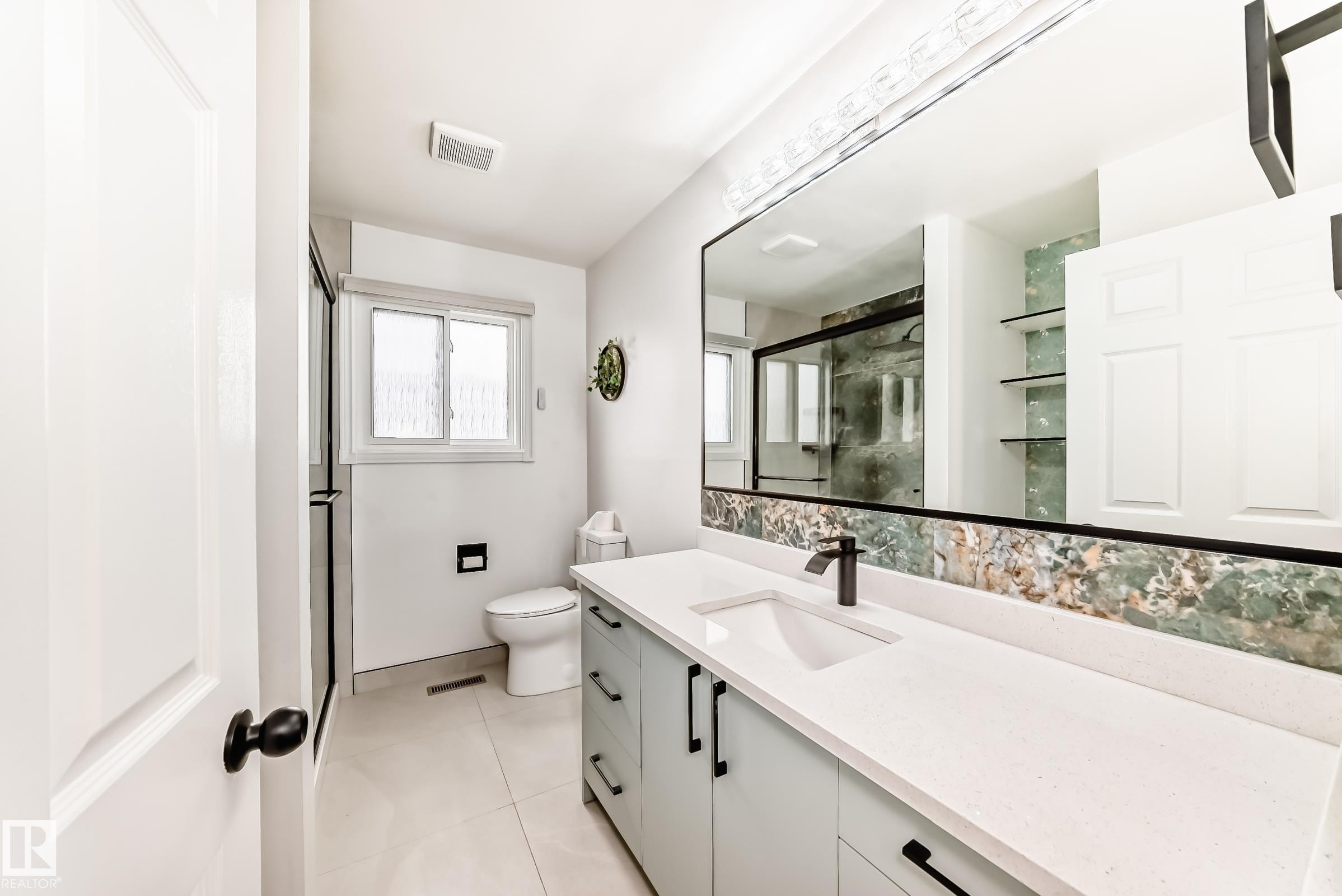 Contemporary bathroom vanity featuring a rectangular undermount sink, matte black faucet, and a large wall-mounted mirror with integrated lighting - 2039 48 Street, Edmonton, AB - Indoor Photo Showing Bathroom