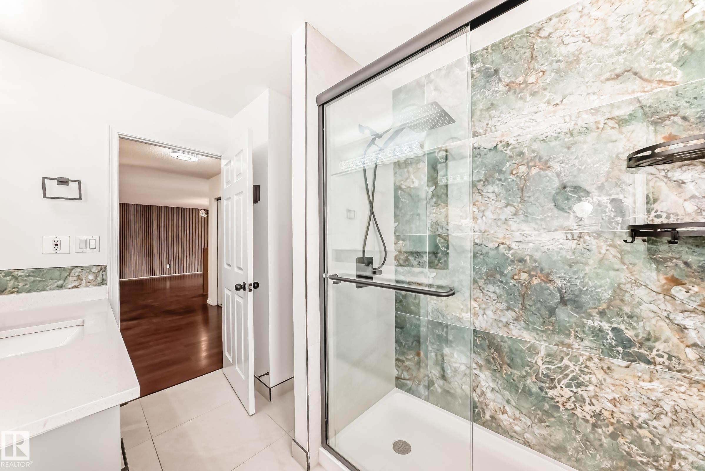 Glass-enclosed shower featuring large format green-toned stone-look tiling and matte black fixtures - 2039 48 Street, Edmonton, AB - Indoor Photo Showing Bathroom