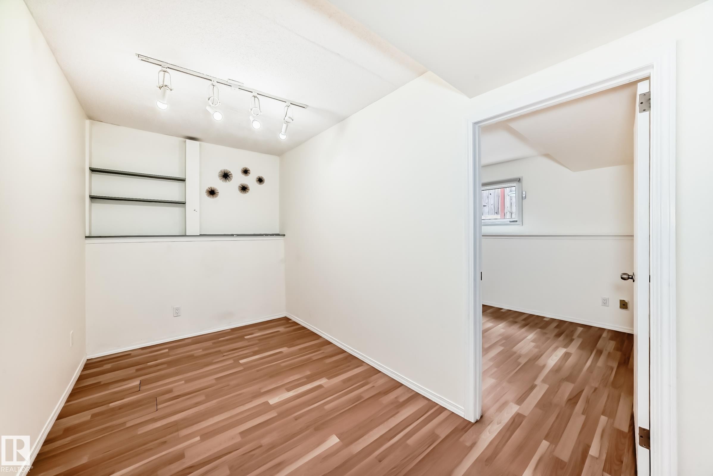 Room featuring wood-finish flooring, track lighting, and built-in shelving - 2039 48 Street, Edmonton, AB - Indoor Photo Showing Other Room