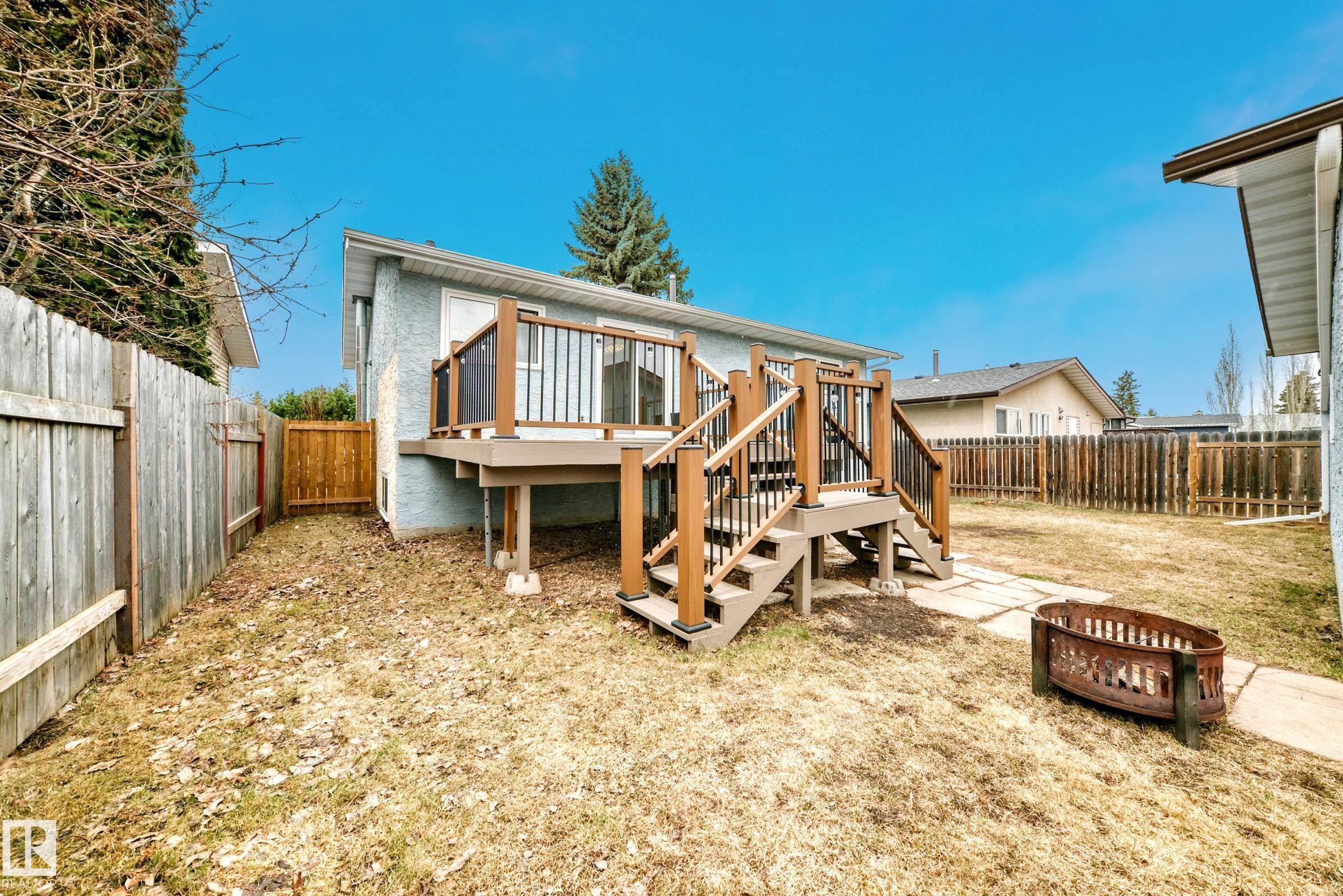 Elevated rear deck with dark wood-tone railing and clear panels - 2039 48 Street, Edmonton, AB - Outdoor With Deck Patio Veranda