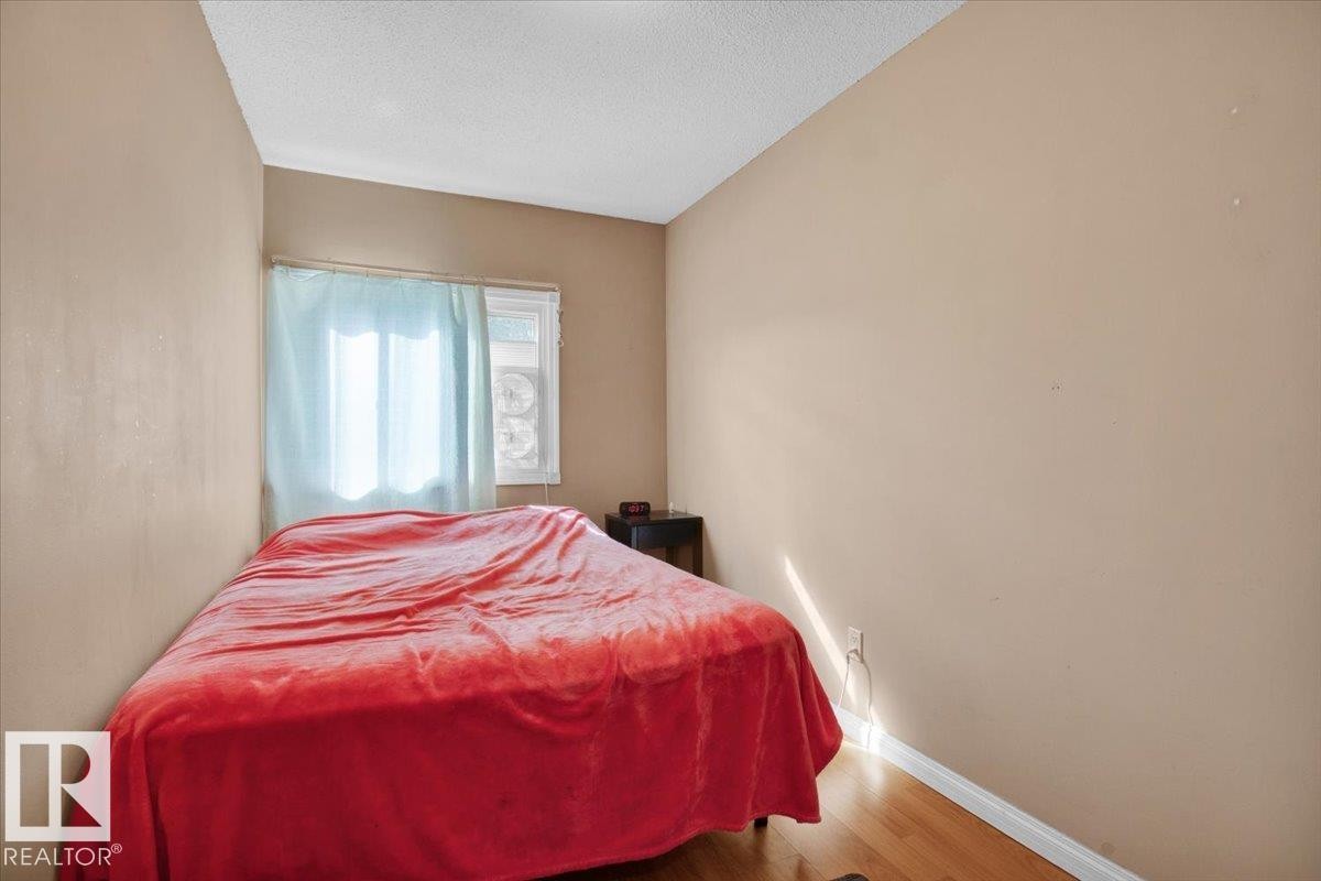 This room features a window with curtains and hardwood flooring - 412 2908 116A Avenue, Edmonton, AB - Indoor Photo Showing Bedroom
