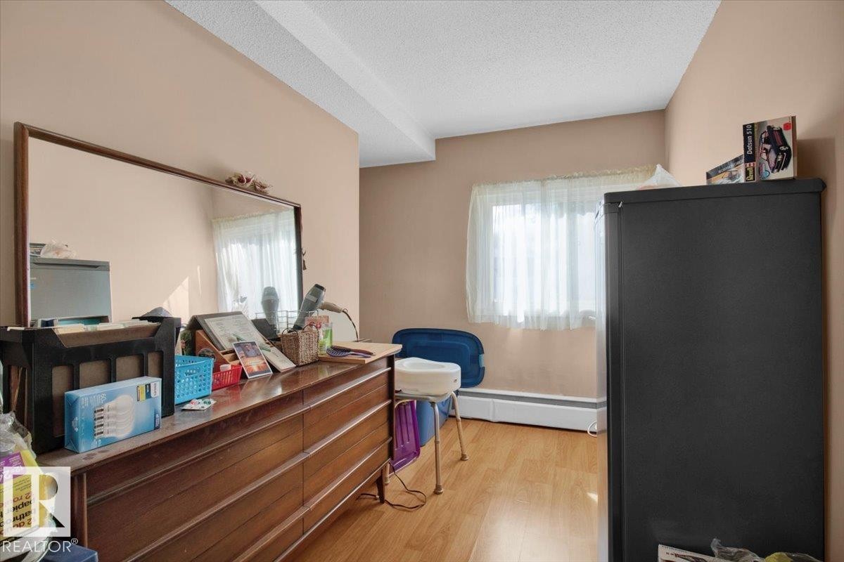 The room features light wood flooring, neutral tone walls, and a window with natural light - 412 2908 116A Avenue, Edmonton, AB - Indoor Photo Showing Other Room