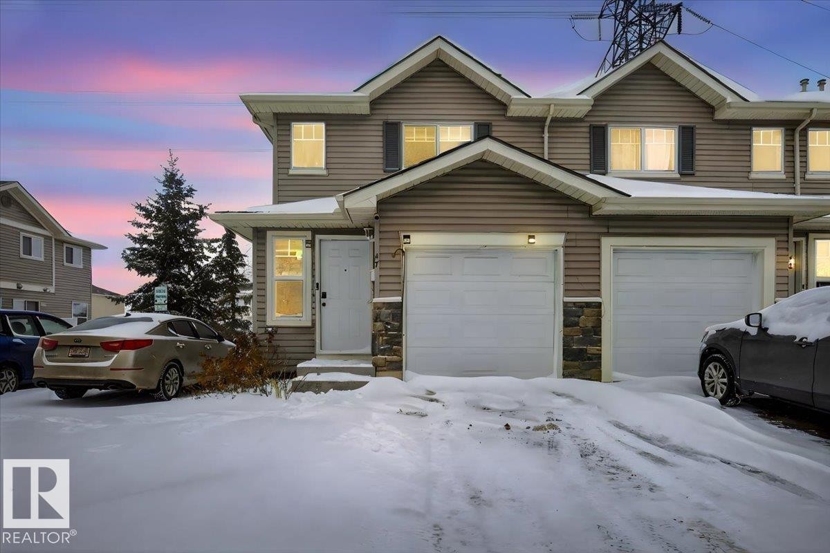 Traditional-style house with stone siding and an attached garage - 47 230 Edwards Drive, Edmonton, AB - Outdoor With Facade