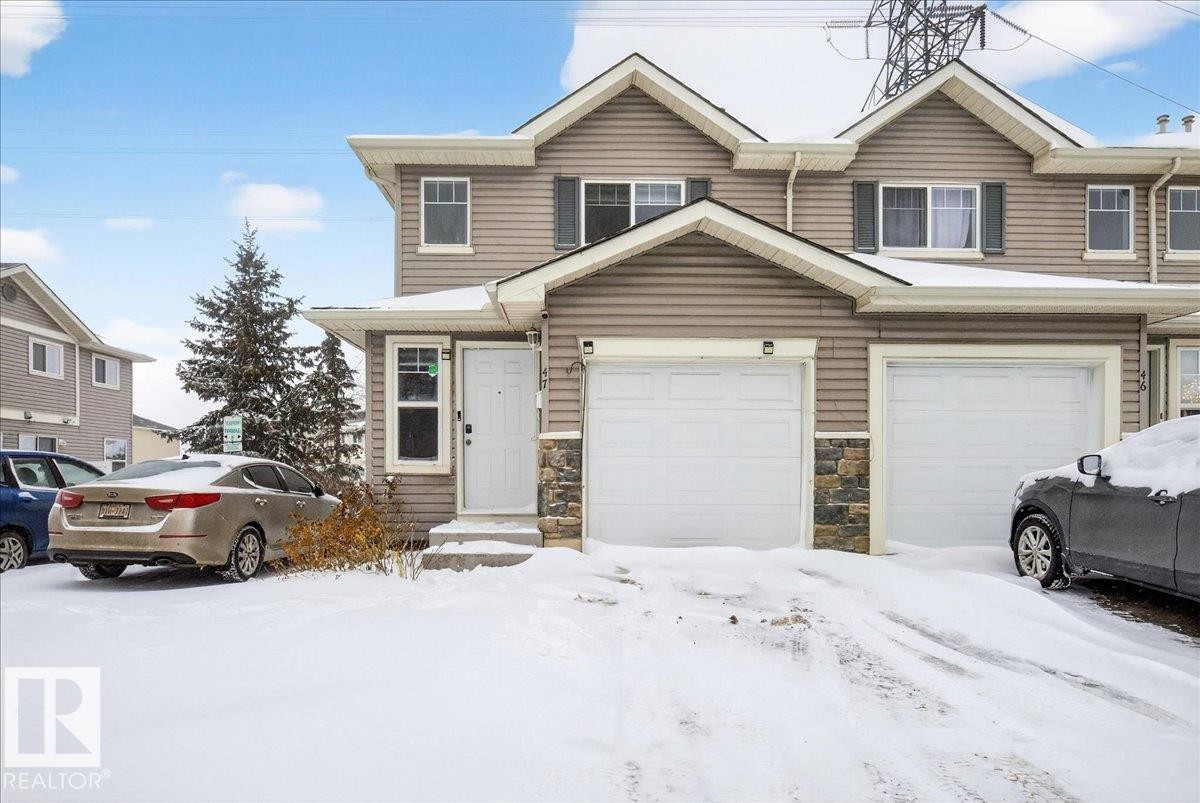 Traditional home with stone siding and an attached garage - 47 230 Edwards Drive, Edmonton, AB - Outdoor With Facade