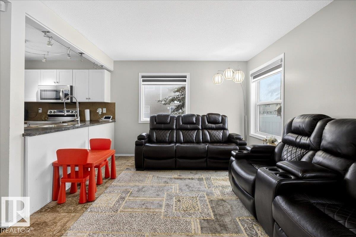 Living room with a textured ceiling and track lighting - 47 230 Edwards Drive, Edmonton, AB - Indoor Photo Showing Living Room