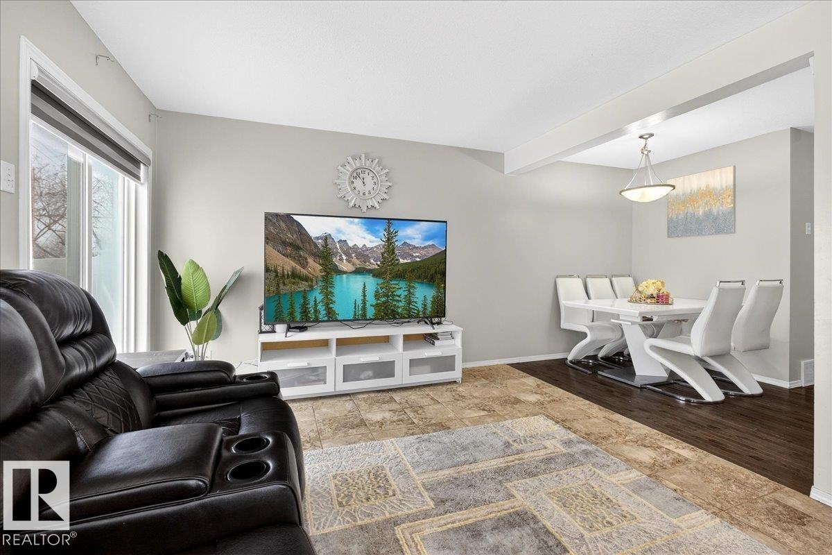 Living area featuring stone tile flooring and beam ceiling - 47 230 Edwards Drive, Edmonton, AB - Indoor