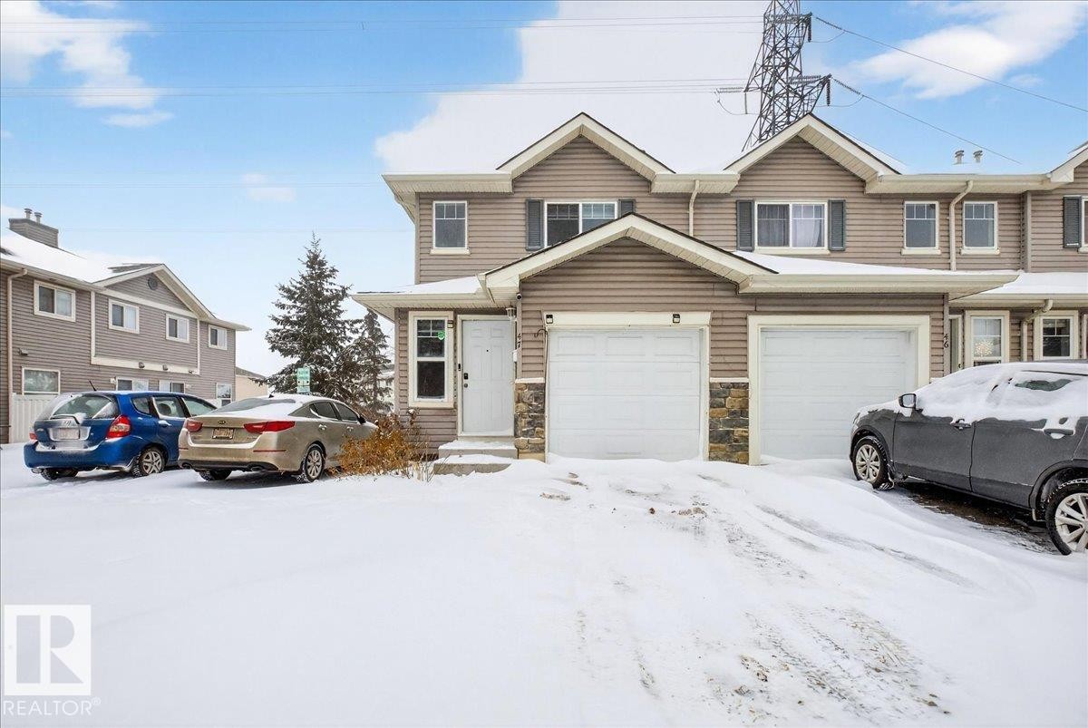 Traditional-style home with stone siding and an attached garage - 47 230 Edwards Drive, Edmonton, AB - Outdoor With Facade